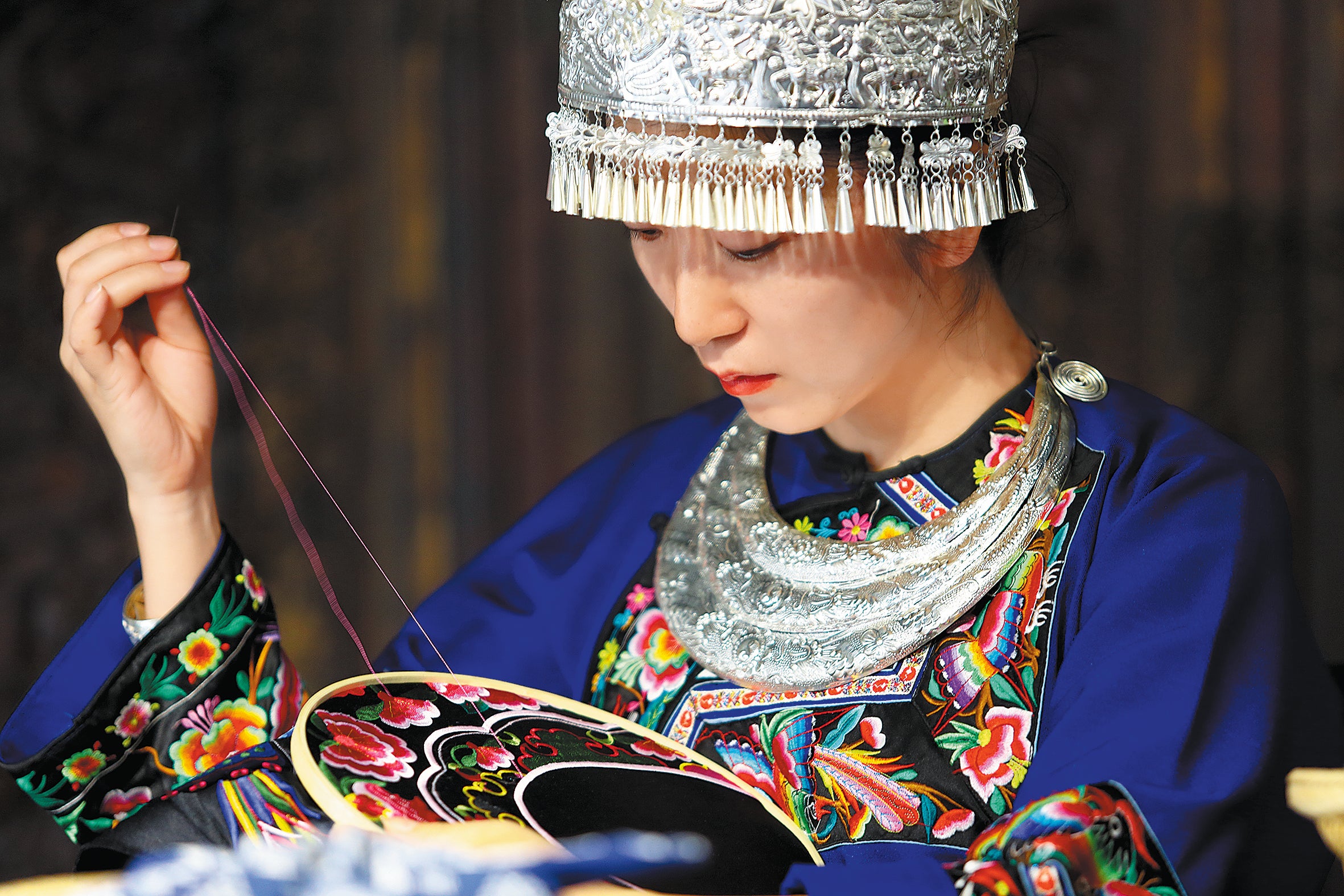 Yi works on a Miao embroidery piece