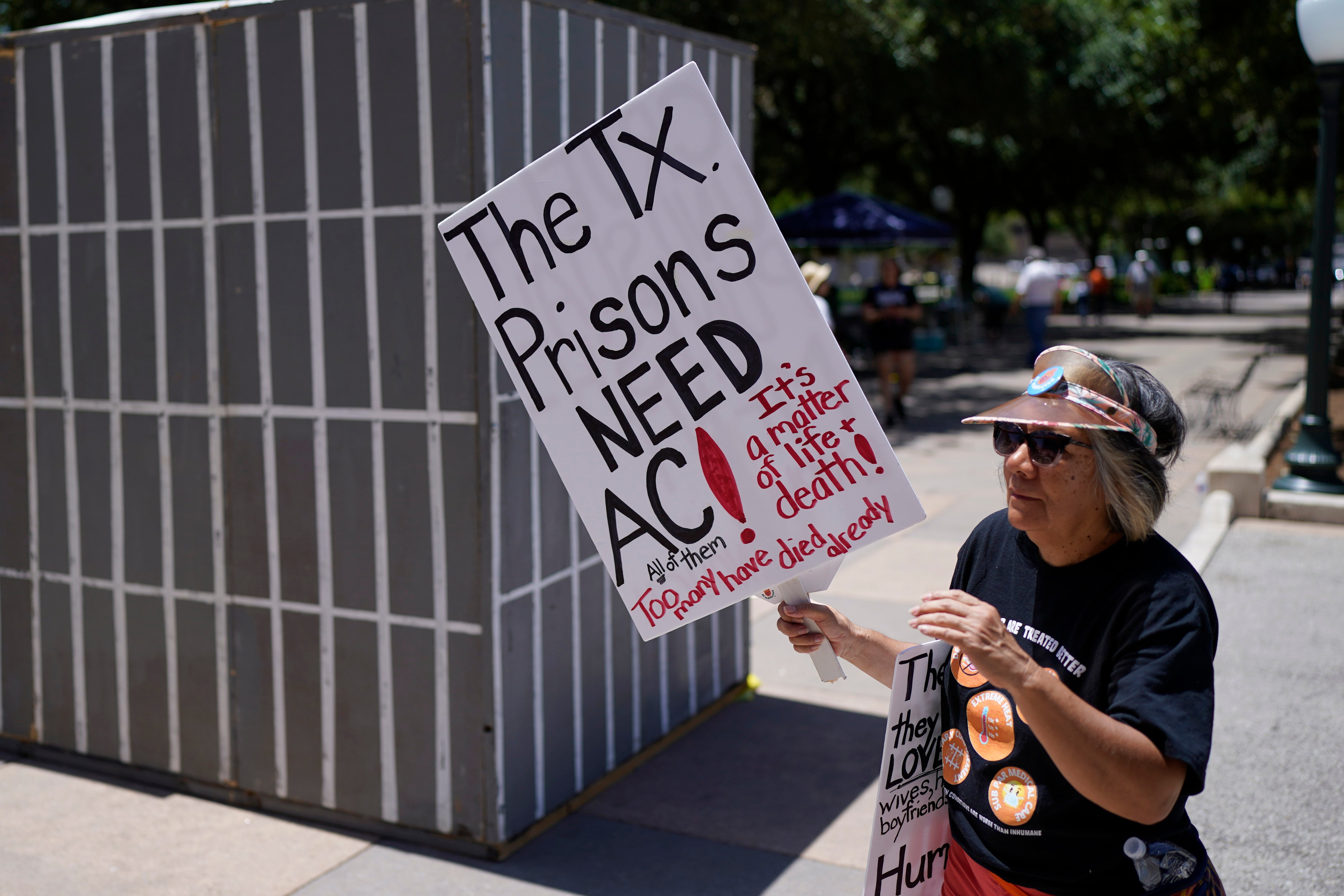 An advocate for cooling Texas prisons walks past a makeshift cell during a rally on the steps of the Texas Capitol, Tuesday, July 18, 2023, in Austin, Texas. The group is calling for an emergency special session to address the deadly heat effecting inmates.