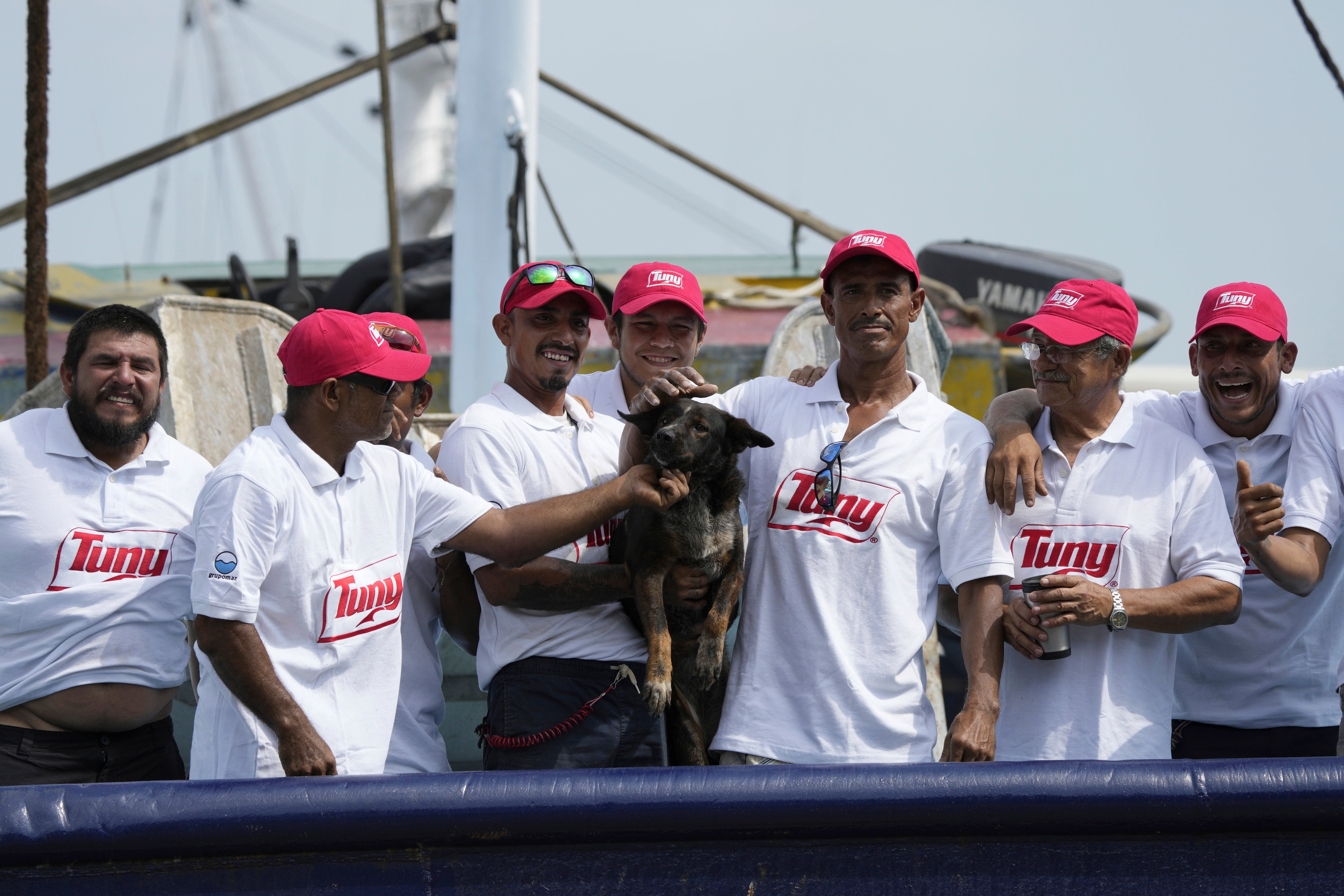 The crew of the Mexican tuna boat Maria Delia, which rescued the pair, pose for photos with Bella