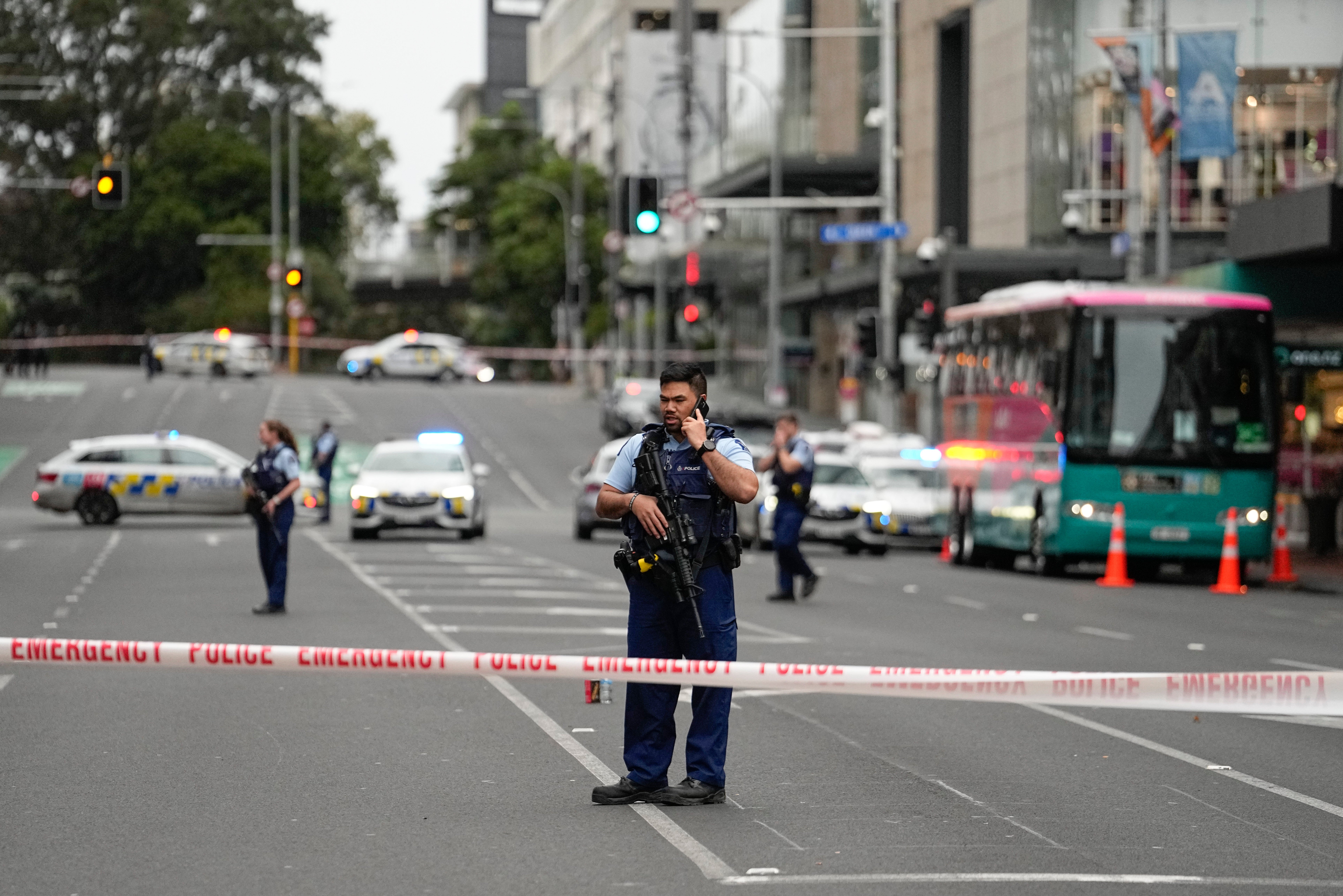 Armed New Zealand police officers stand at a road block in the central business district following a shooting in Auckland, New Zealand, Thursday, July 20, 2023