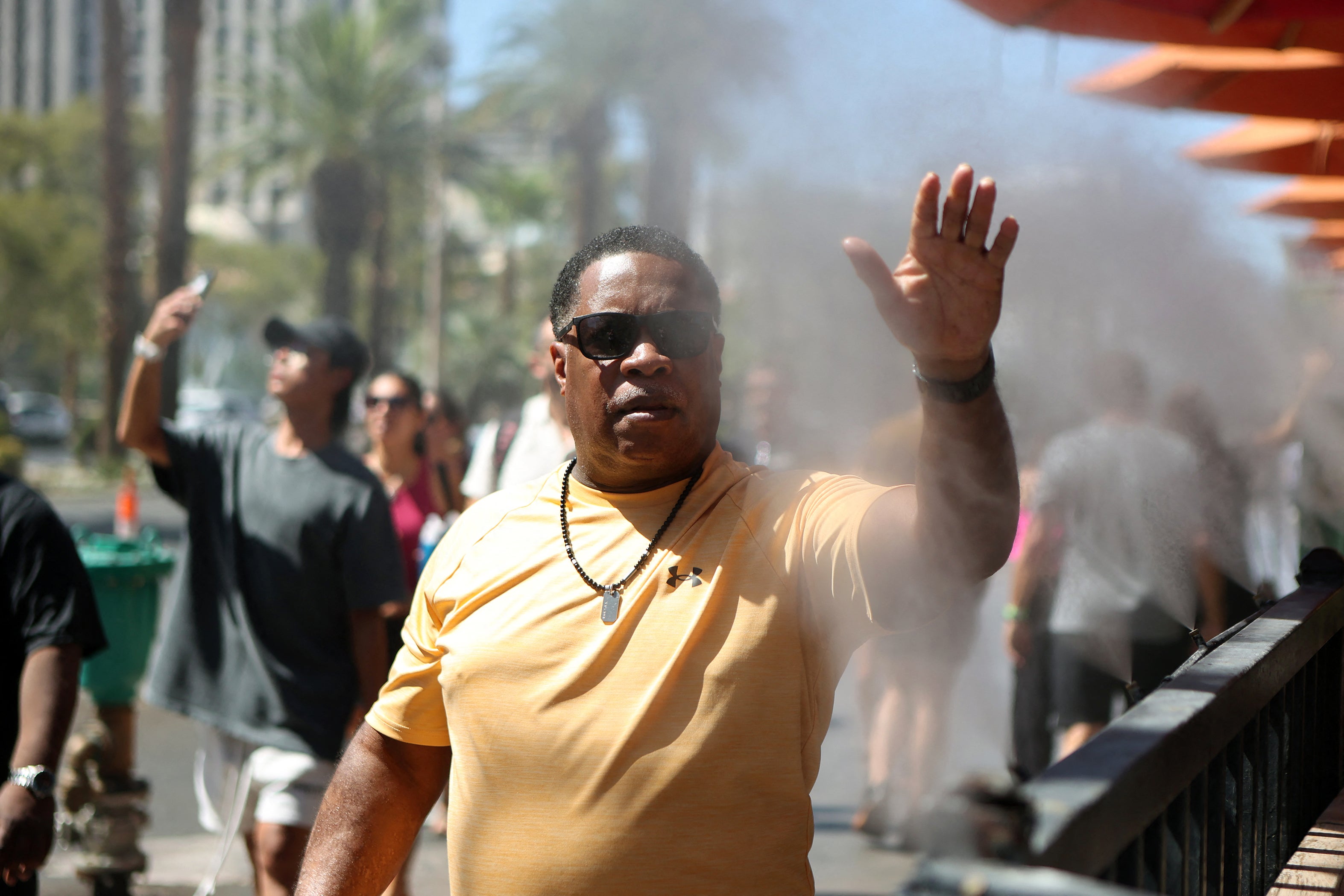 A pedestrian cools off in water sprinklers along the sidewalk during a heat wave in Las Vegas, Nevada last week
