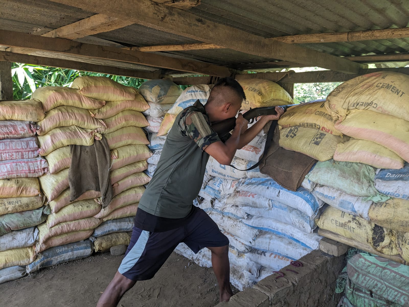 A resident in Singda village of Kadangband behind a sandbag bunker