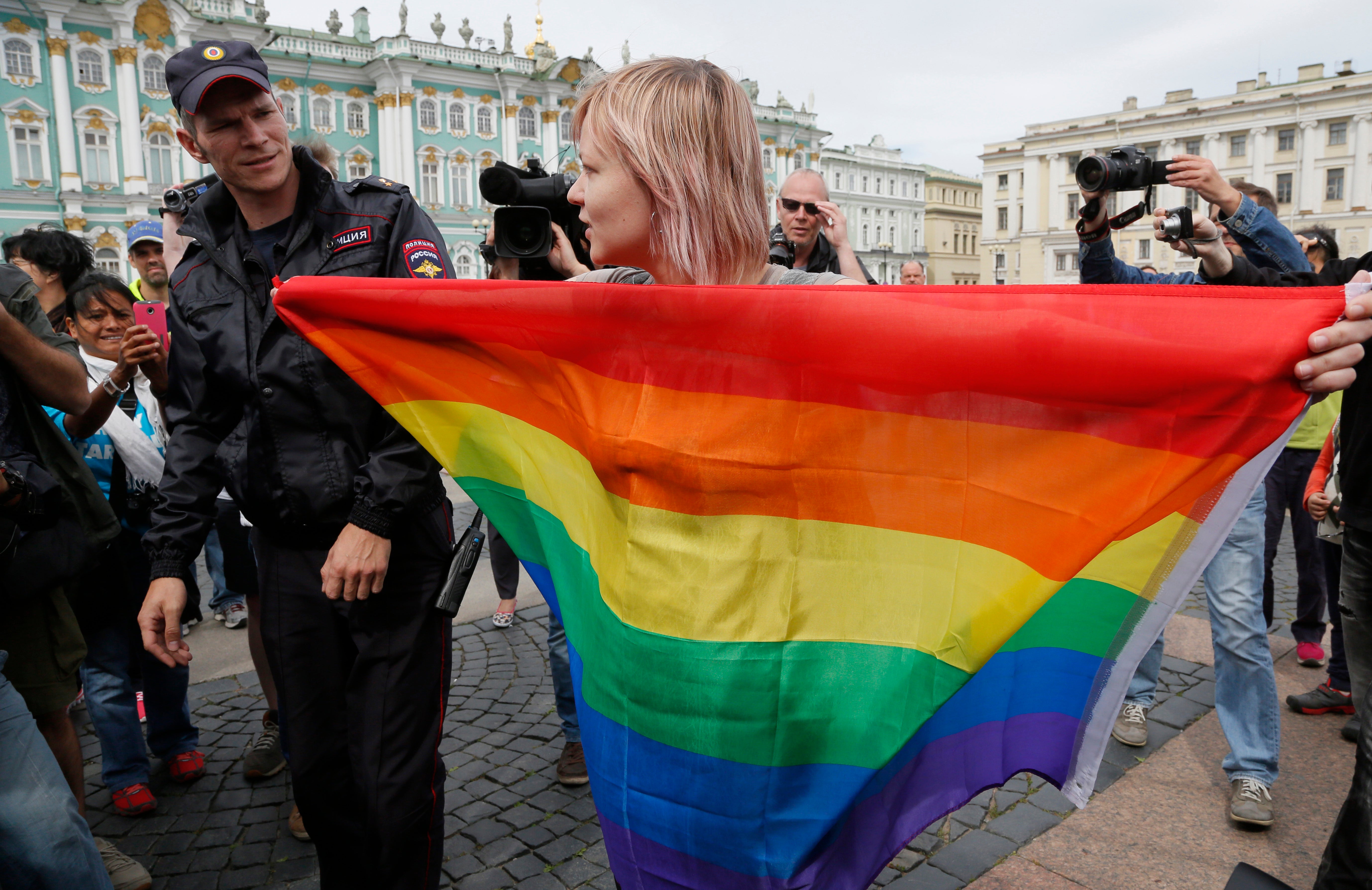 A police officer speaks with a gay rights activist standing with a rainbow flag at Dvortsovaya Square in St. Petersburg, Russia (File photo)