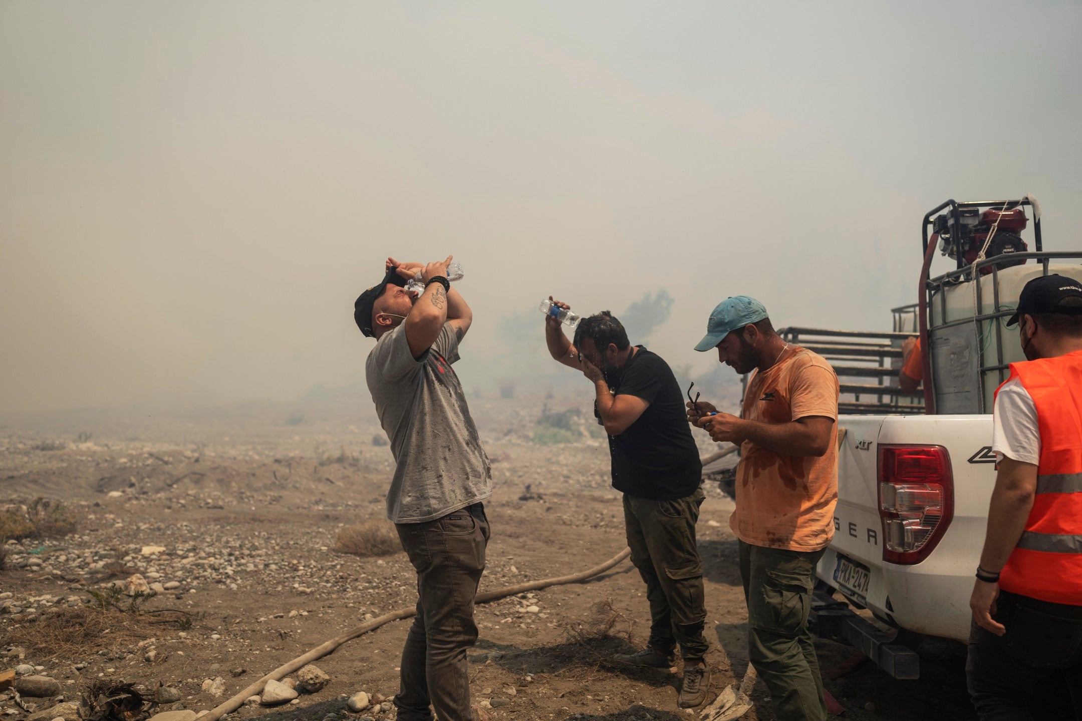 Volunteers cool themselves during a wildfire in Vati village, on the Aegean Sea island of Rhodes