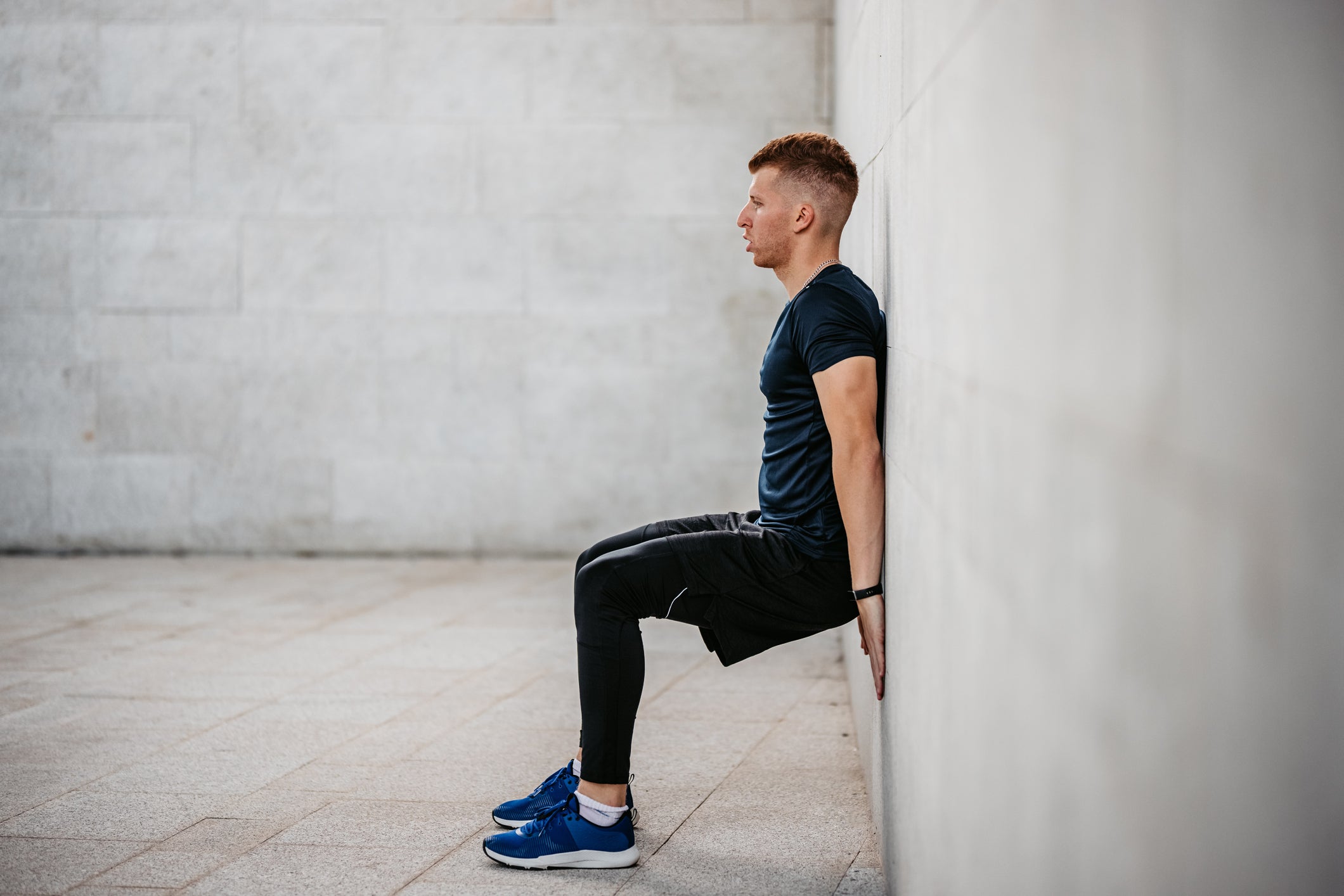 A man demonstrating a wall sit exercise