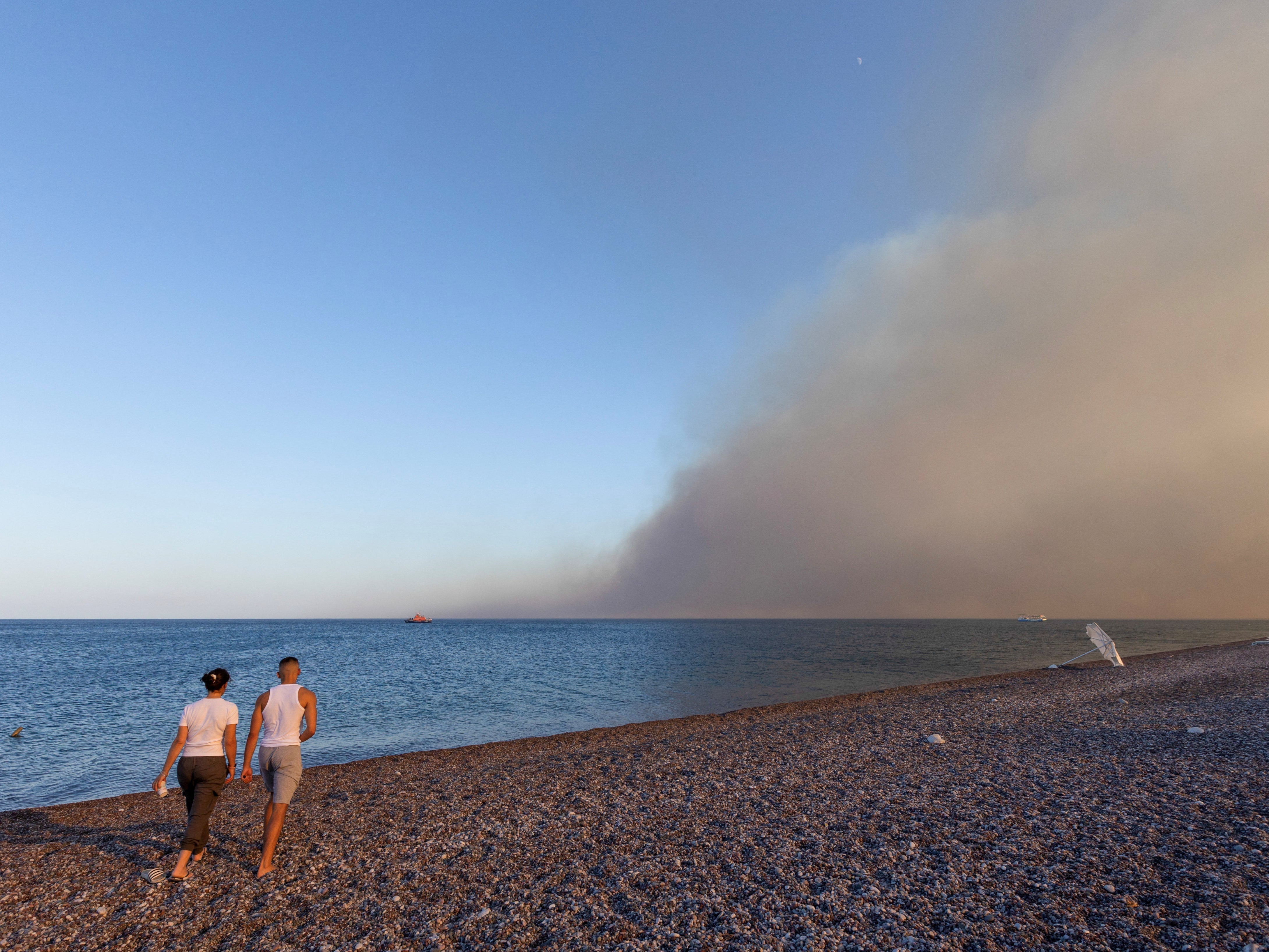 Let’s go to the beach: A couple walk on the shore in Rhodes