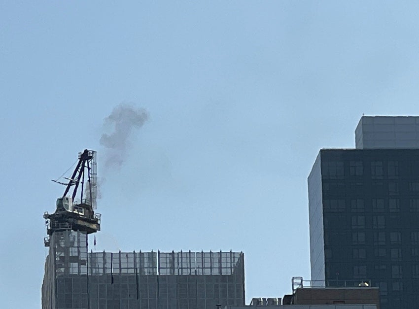 Smoke billows into the air from the crane