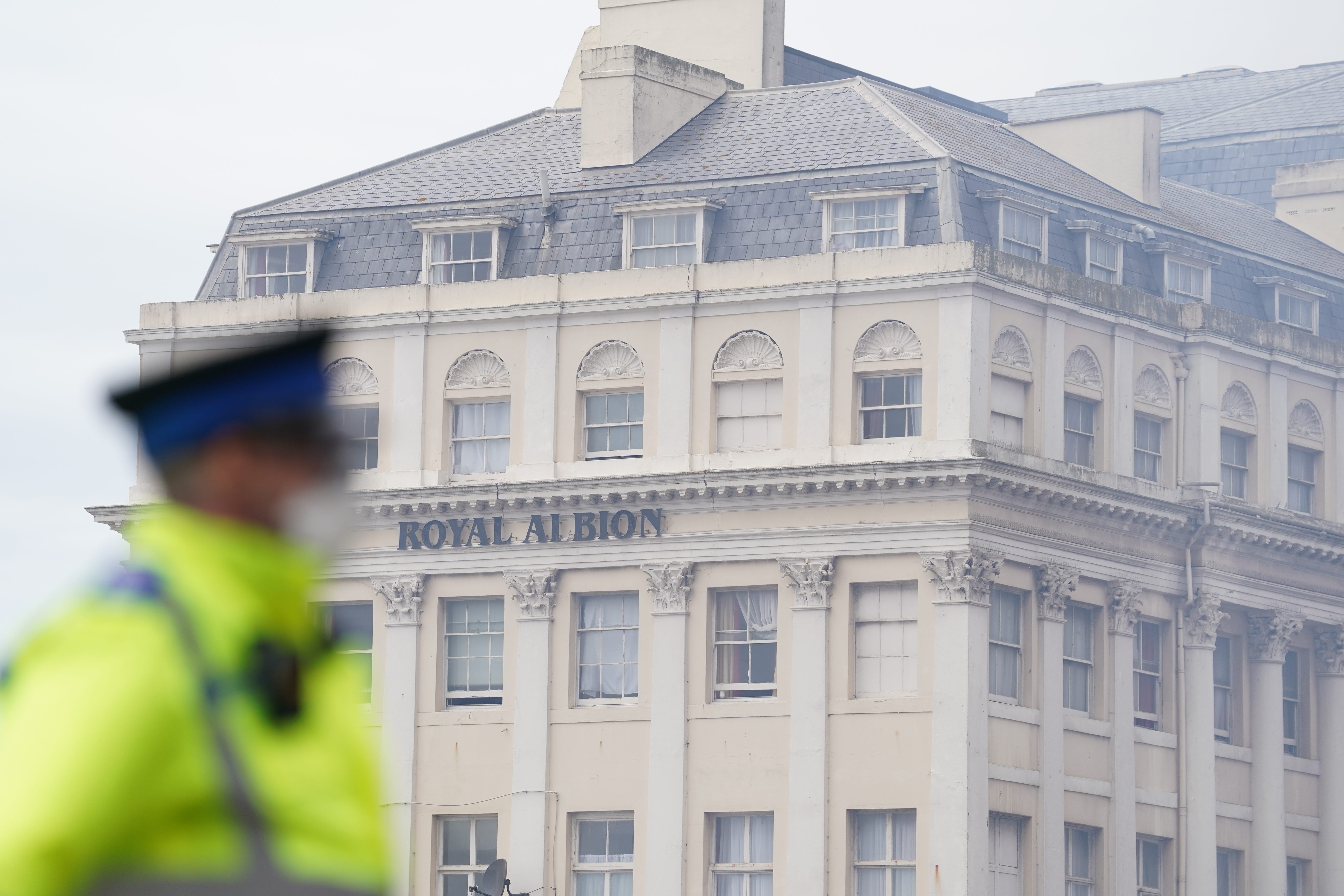 A police community support officer wears goggles and a face mask at the scene in Brighton after a fire at the Royal Albion Hotel (Gareth Fuller/PA)