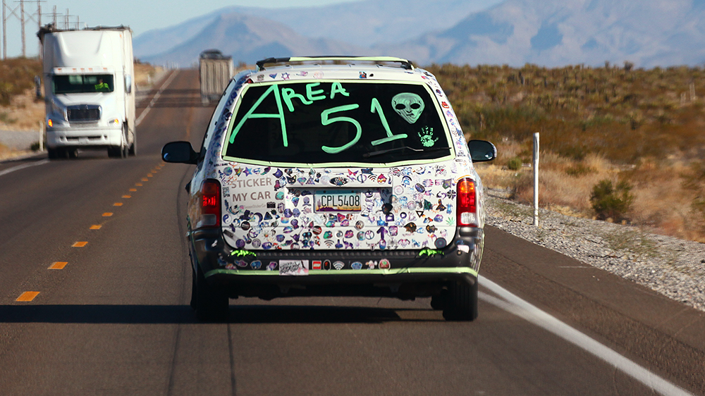 A car drives with 'Area 51' written on the back before the start of a 'Storm Area 51' spinoff event in 2019