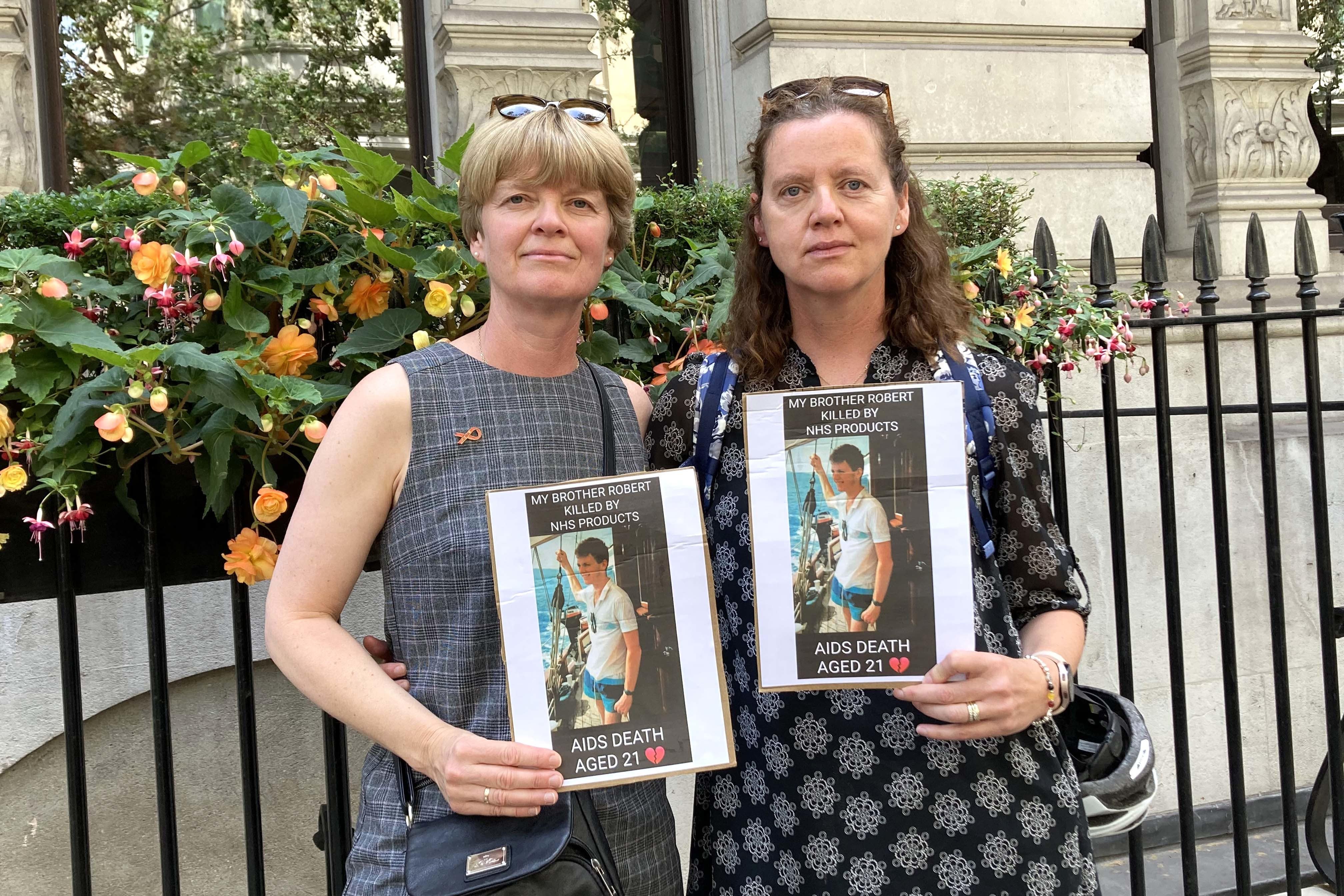 Liz Gardner (left) and Meg Parsons holding pictures of their brother Robert Gibbs outside the Infected Blood Inquiry in London. Mr Gibbs died aged 21 after finding out he was HIV positive aged 15. Picture date: Wednesday July 26, 2023. (PA)