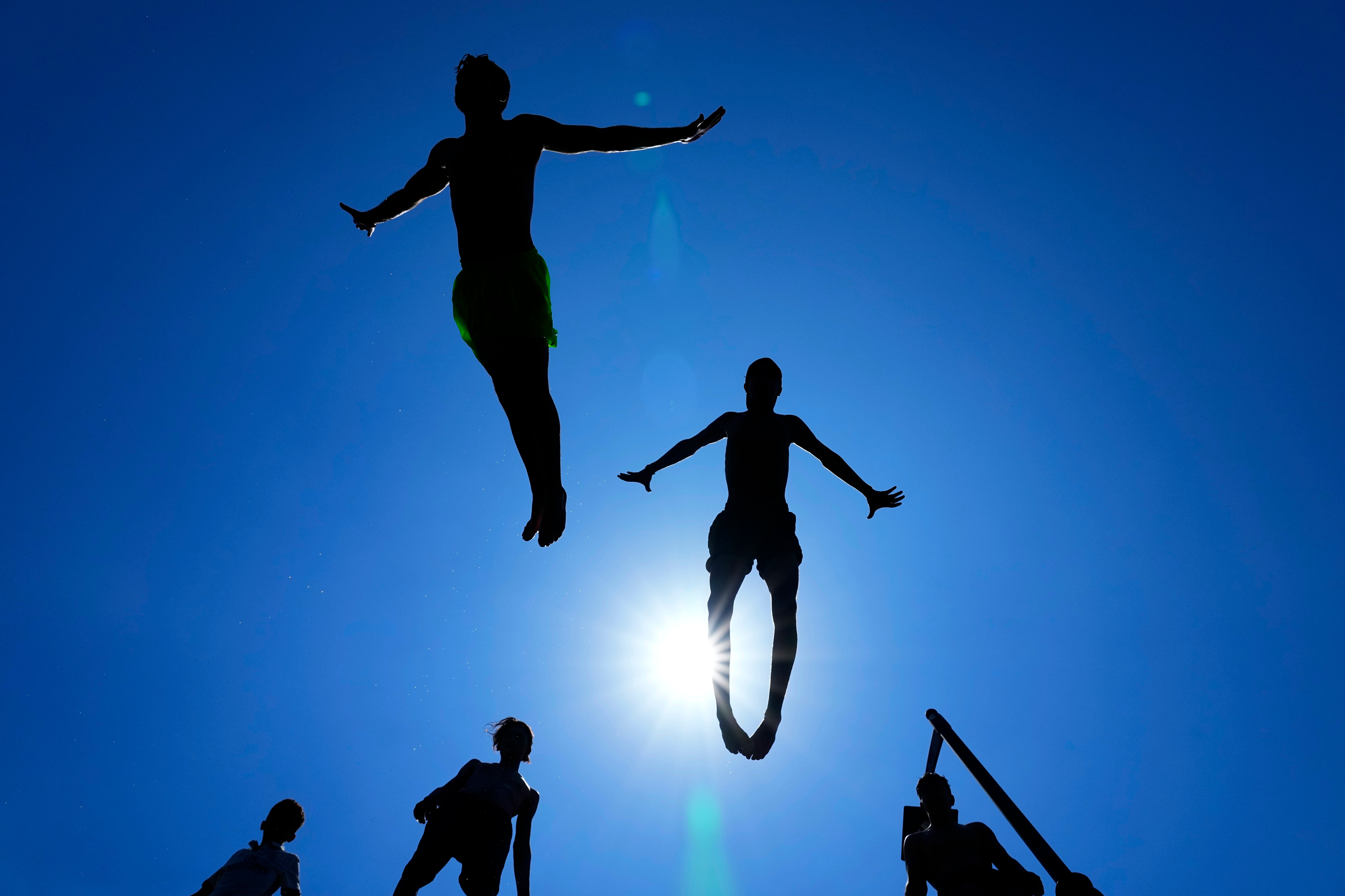 Young people jump into the water to cool down on a sweltering hot day at the Mediterranean Sea in Beirut, Lebanon