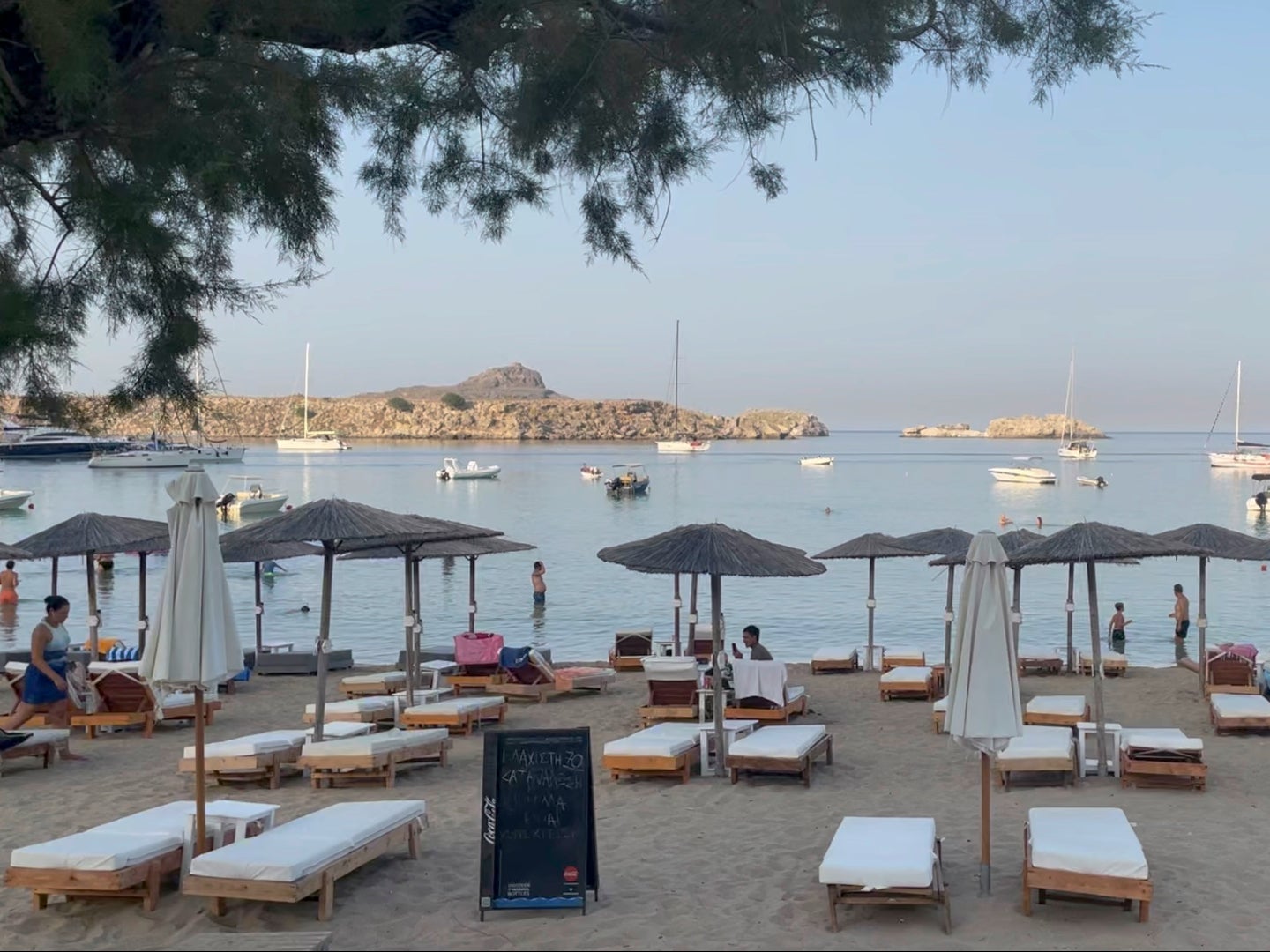 Holidaymakers visited Lindos beach on Thursday as firefighting efforts continued just a few miles south near Vati