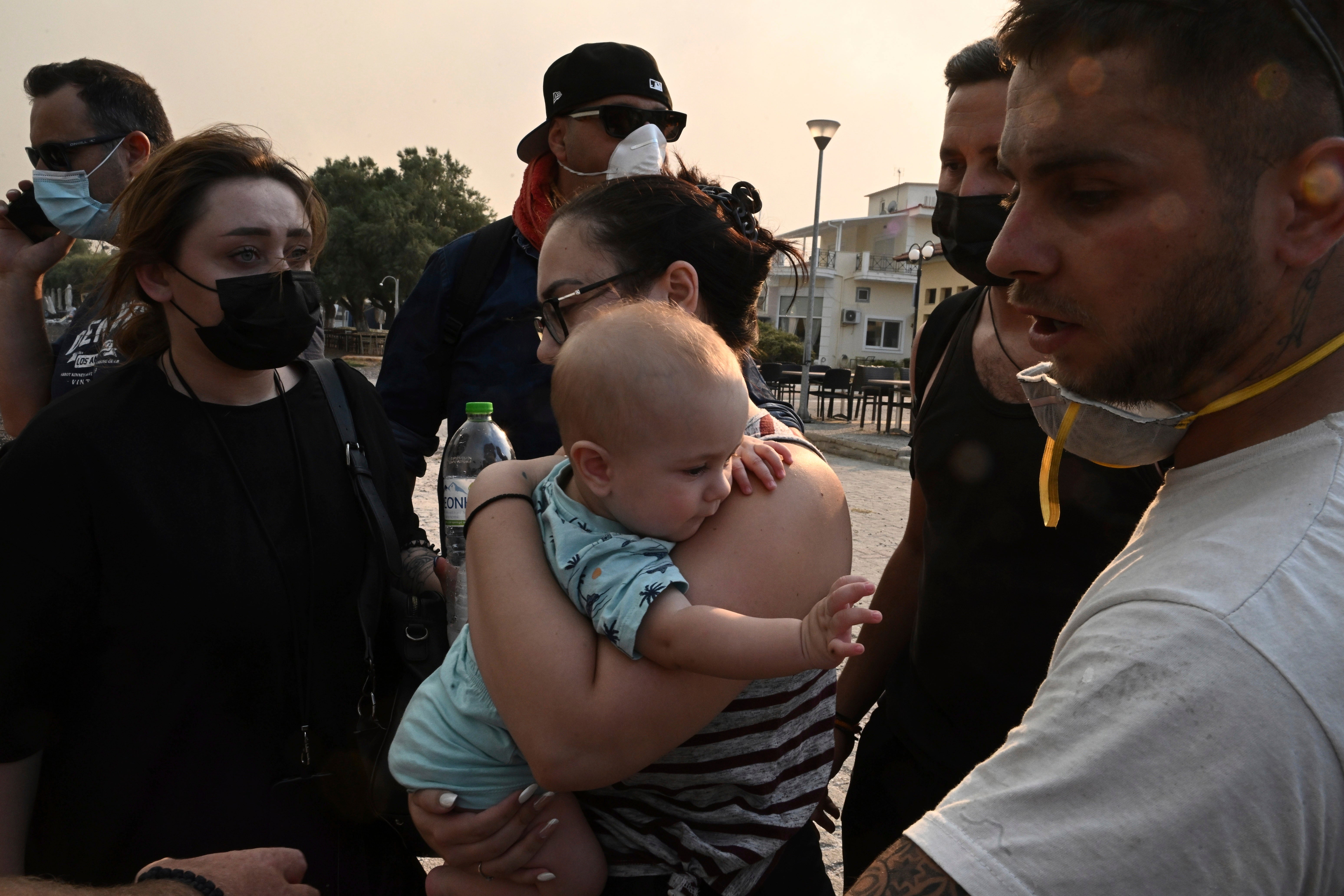 Residents and tourists evacuate with the support of vessels from the town of Nea Anchialos