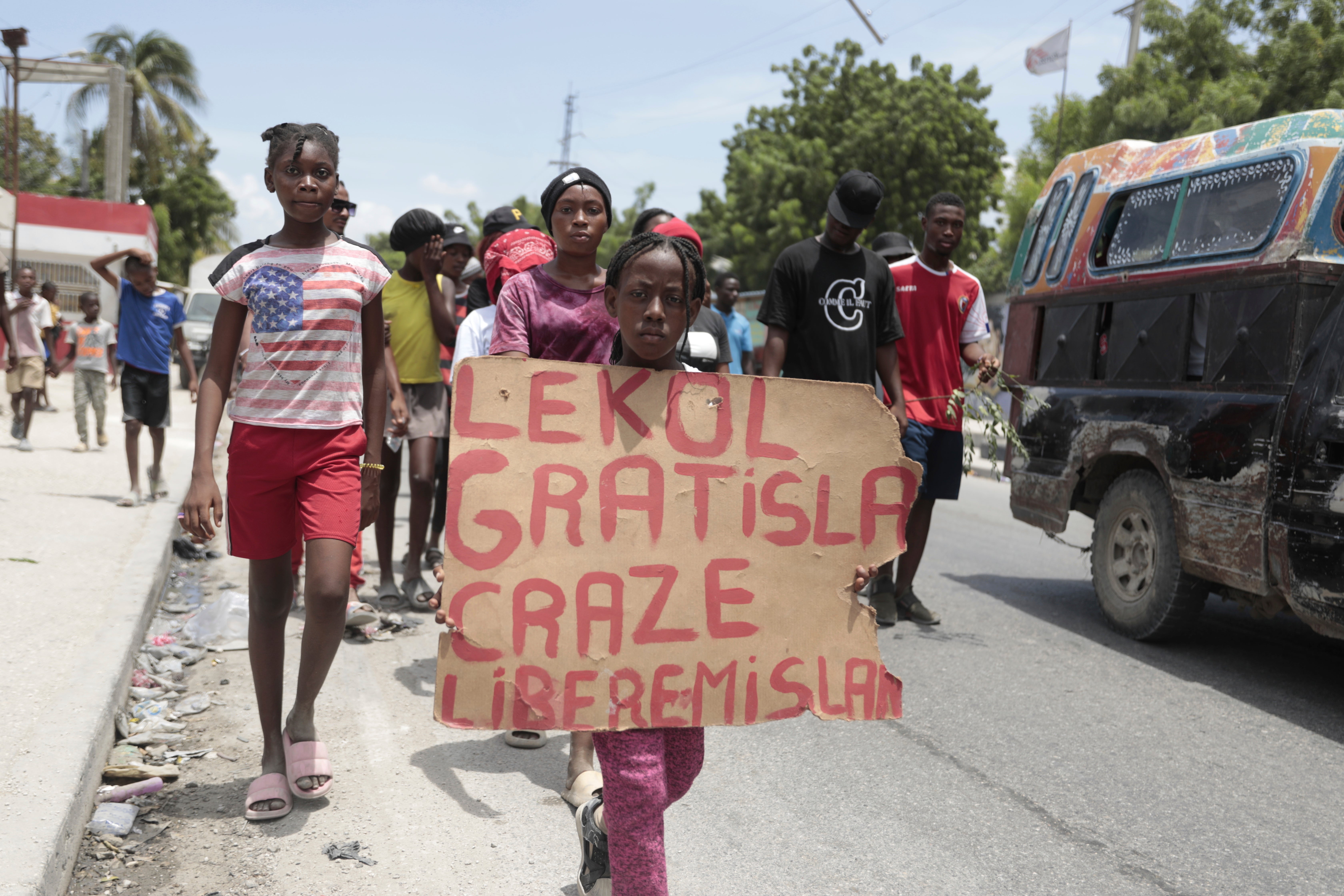 A girl carries a sign that reads in Creole “Free school is broken. Release the nurse,” during a march to demand the freedom of New Hampshire nurse Alix Dorsainvil and her daughter, who have been reported kidnapped