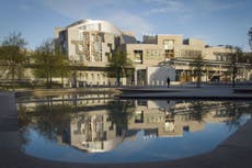 Climate protesters spray Scottish Parliament building red