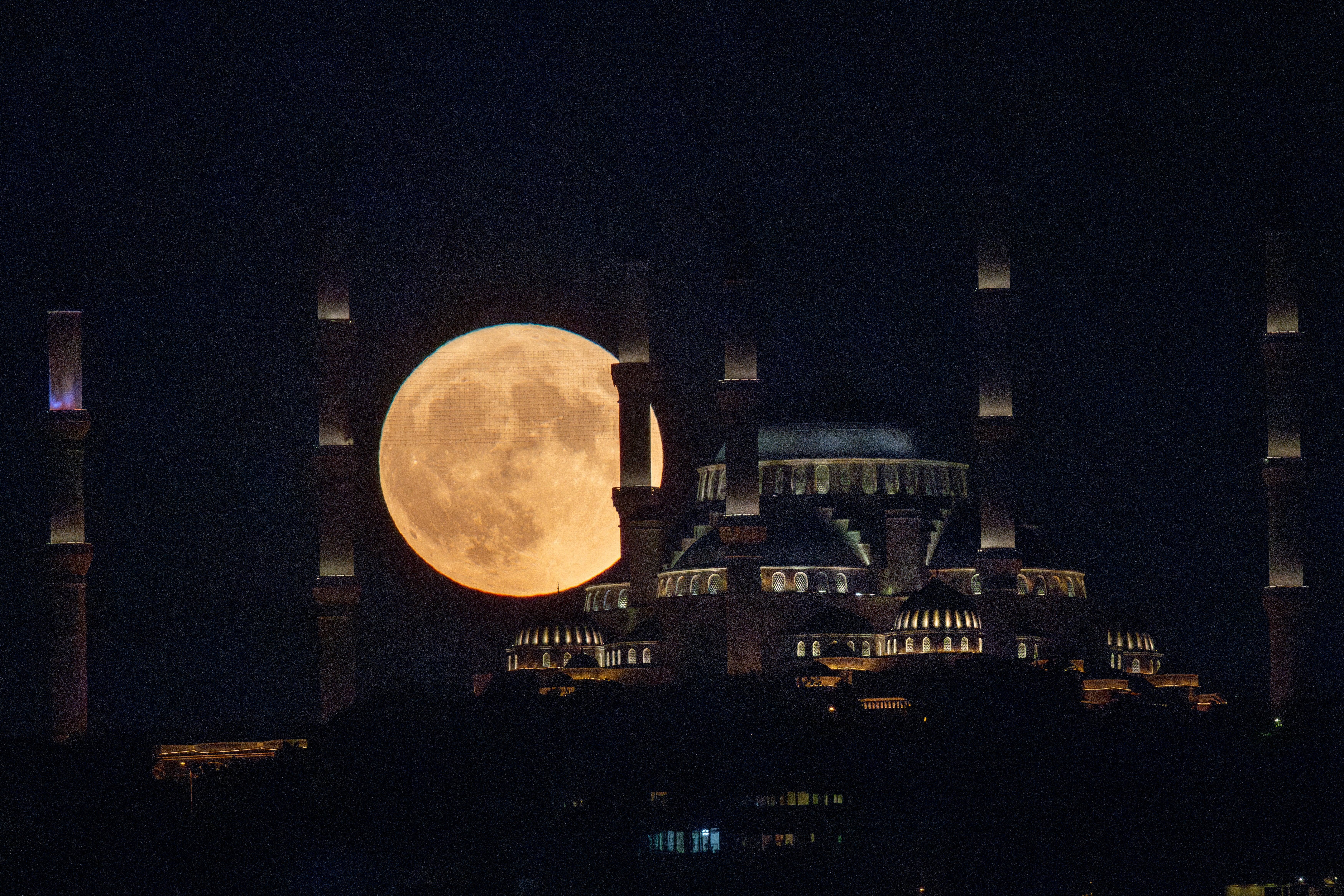 The Sturgeon full moon rises behind Istanbul's Camlica Mosque on August 01, 2023 in Istanbul, Turkey