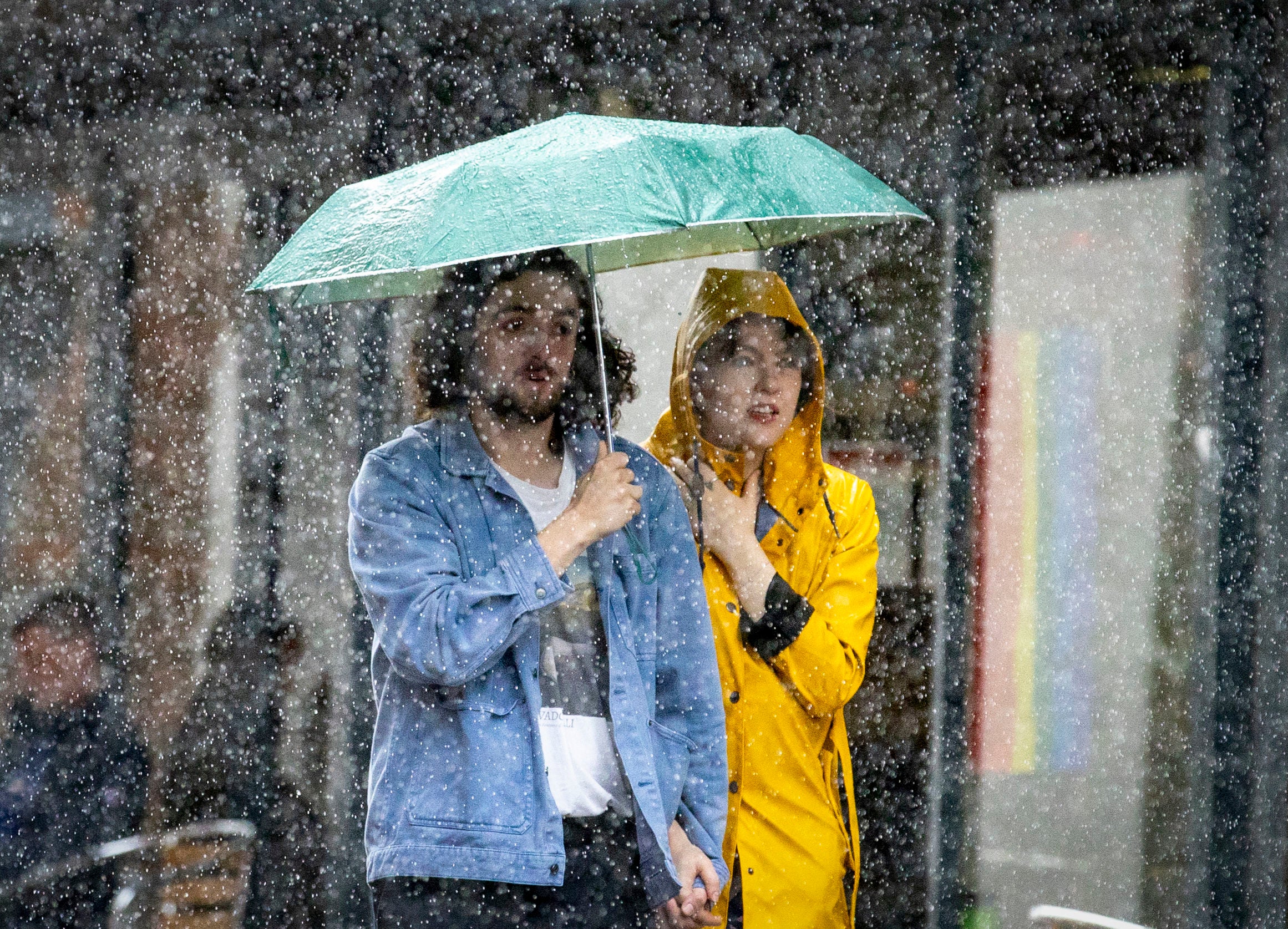 A couple shelter under an umbrella during a heavy downpour of rain in Belfast, Monday 31 July