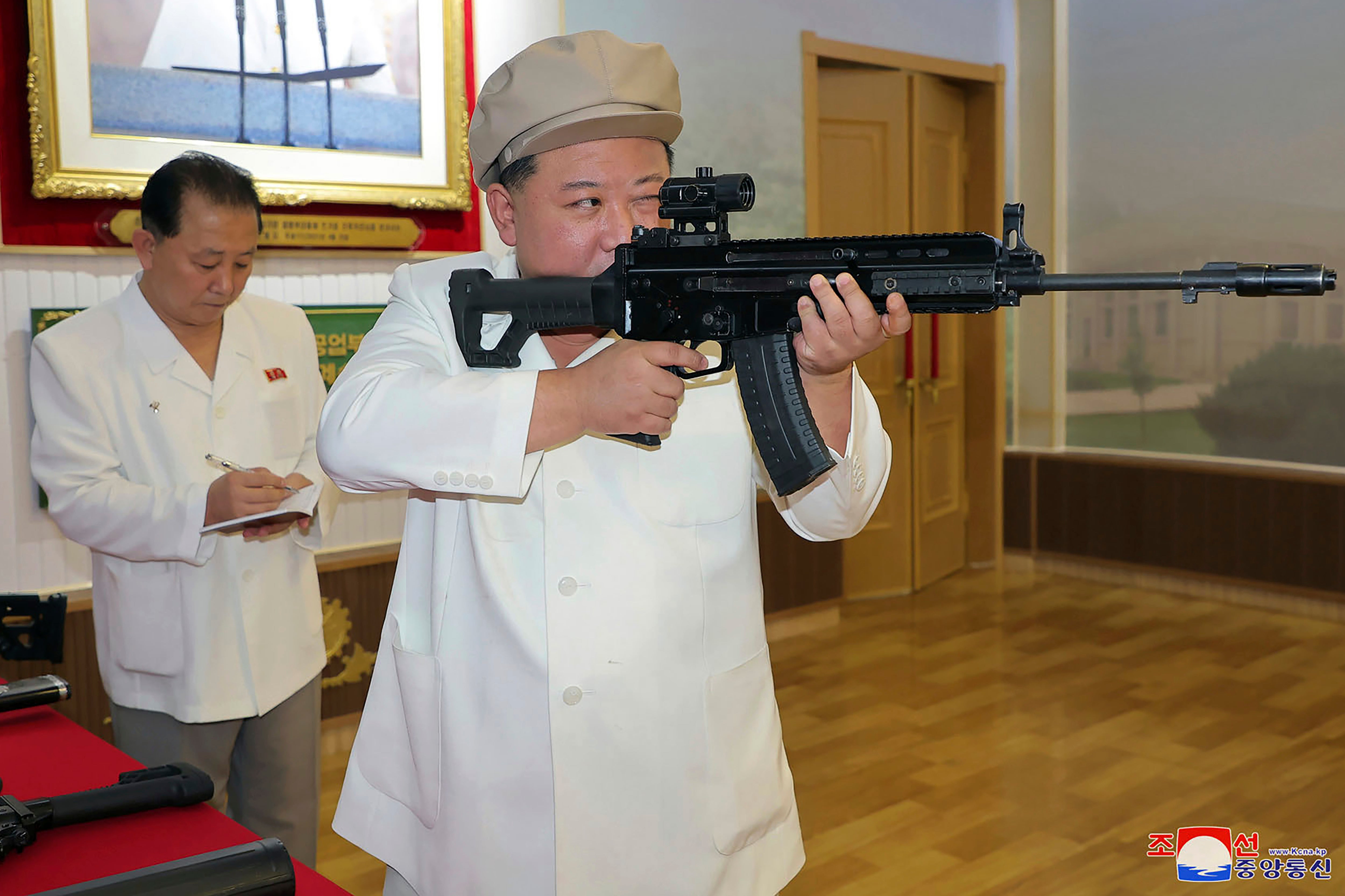 North Korean leader Kim Jong Un holds a weapon during his three-day inspection at a major munitions factories in North Korea