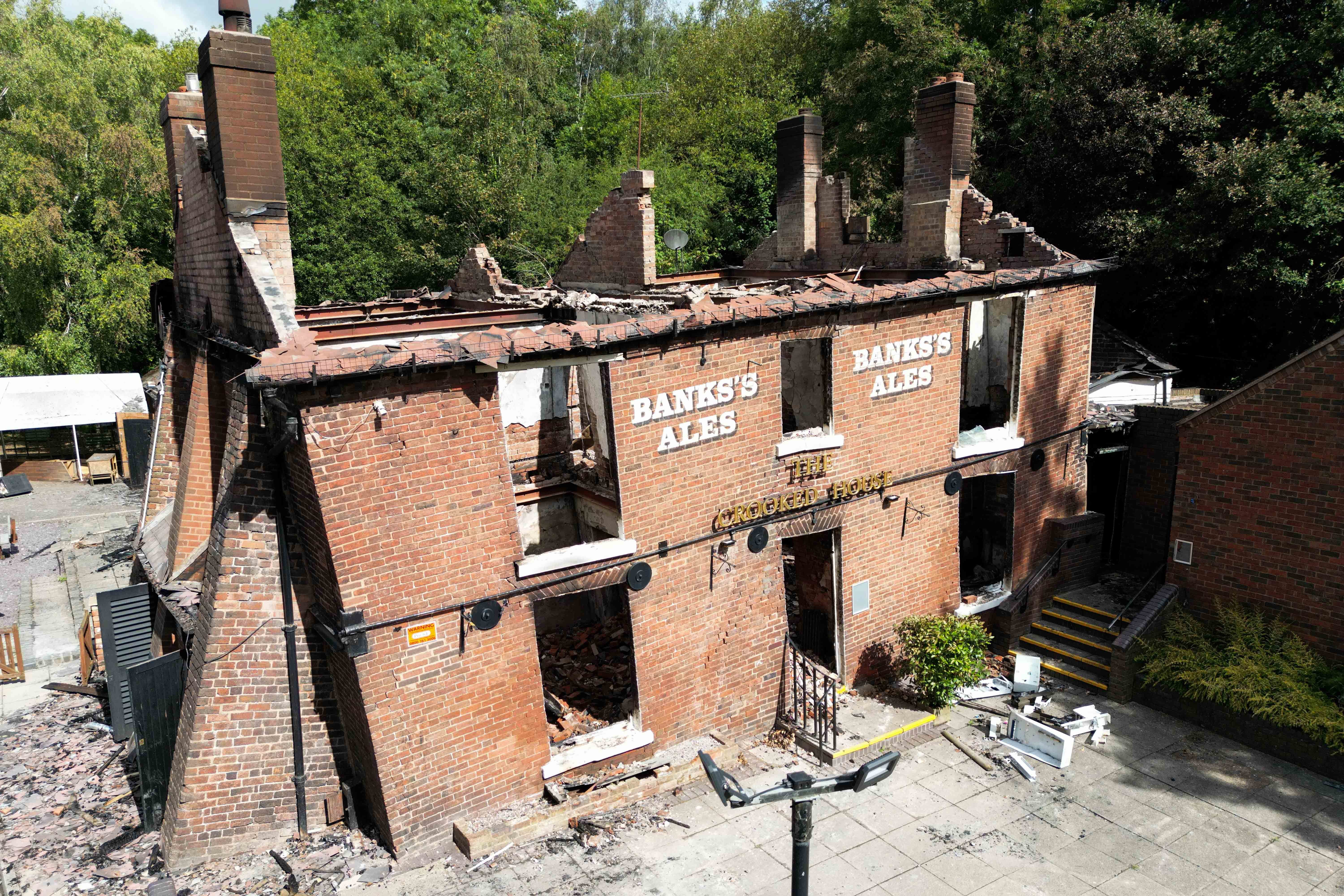 The burnt out remains of The Crooked House pub before it was demolished (Jacob King/PA)