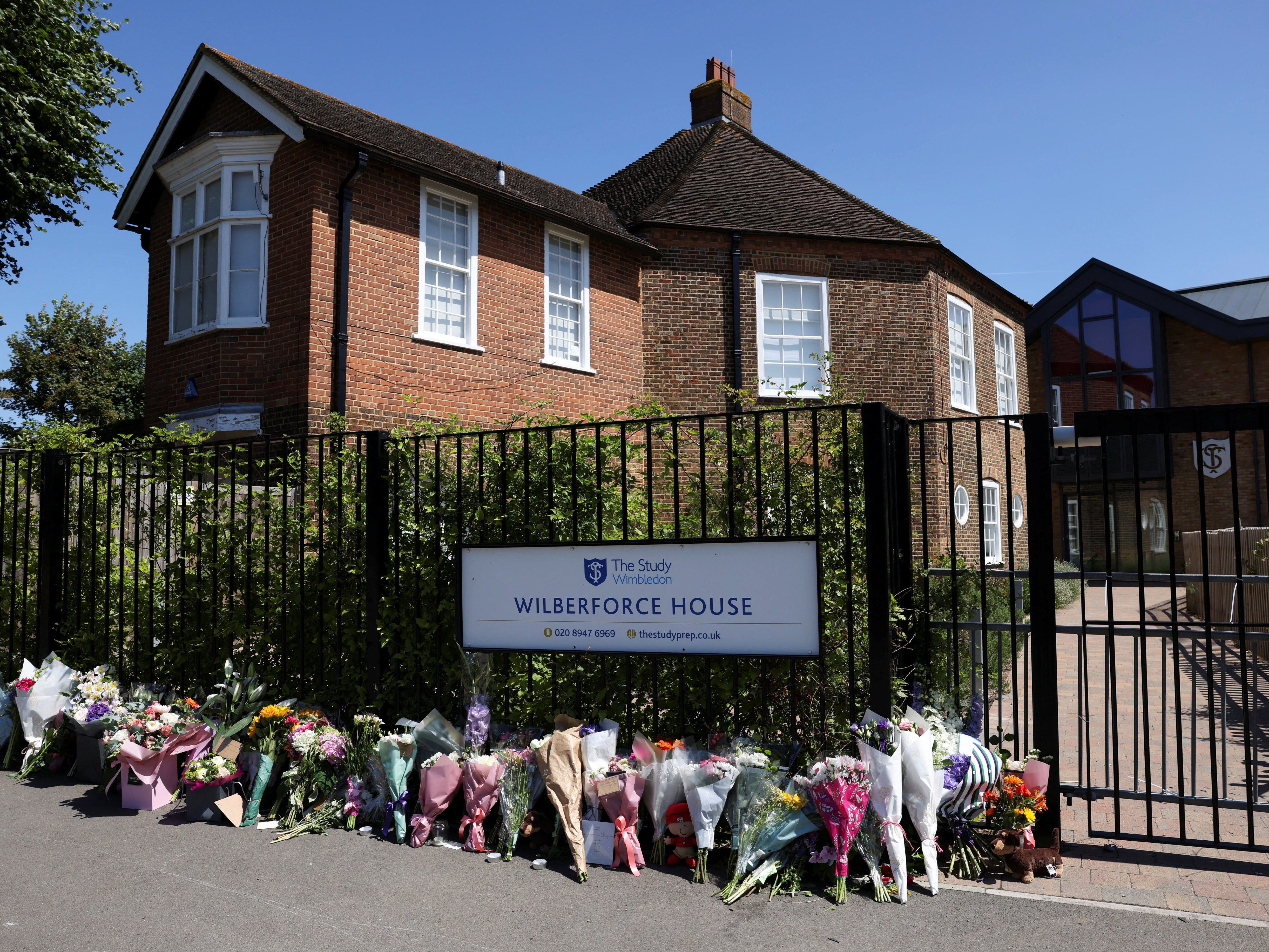 Floral tributes for the two eight-year-old girls who died in the crash are laid outside a school gate