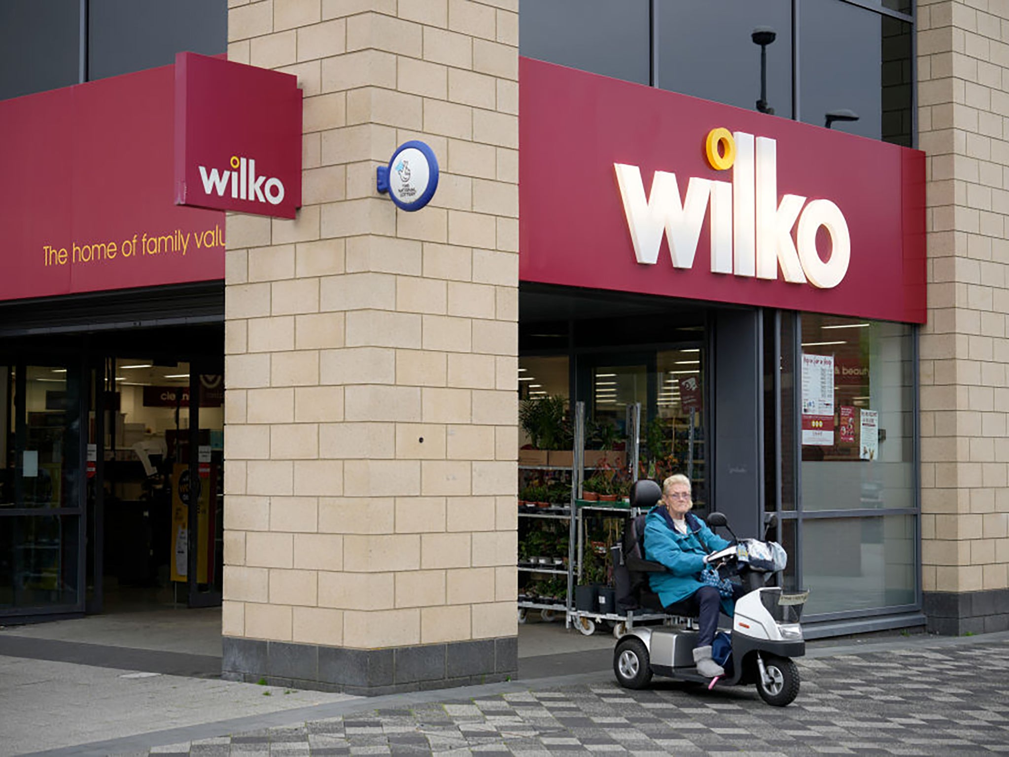 A woman in a mobility scooter leaves the Wythenshawe branch of Wilco in Manchester in August