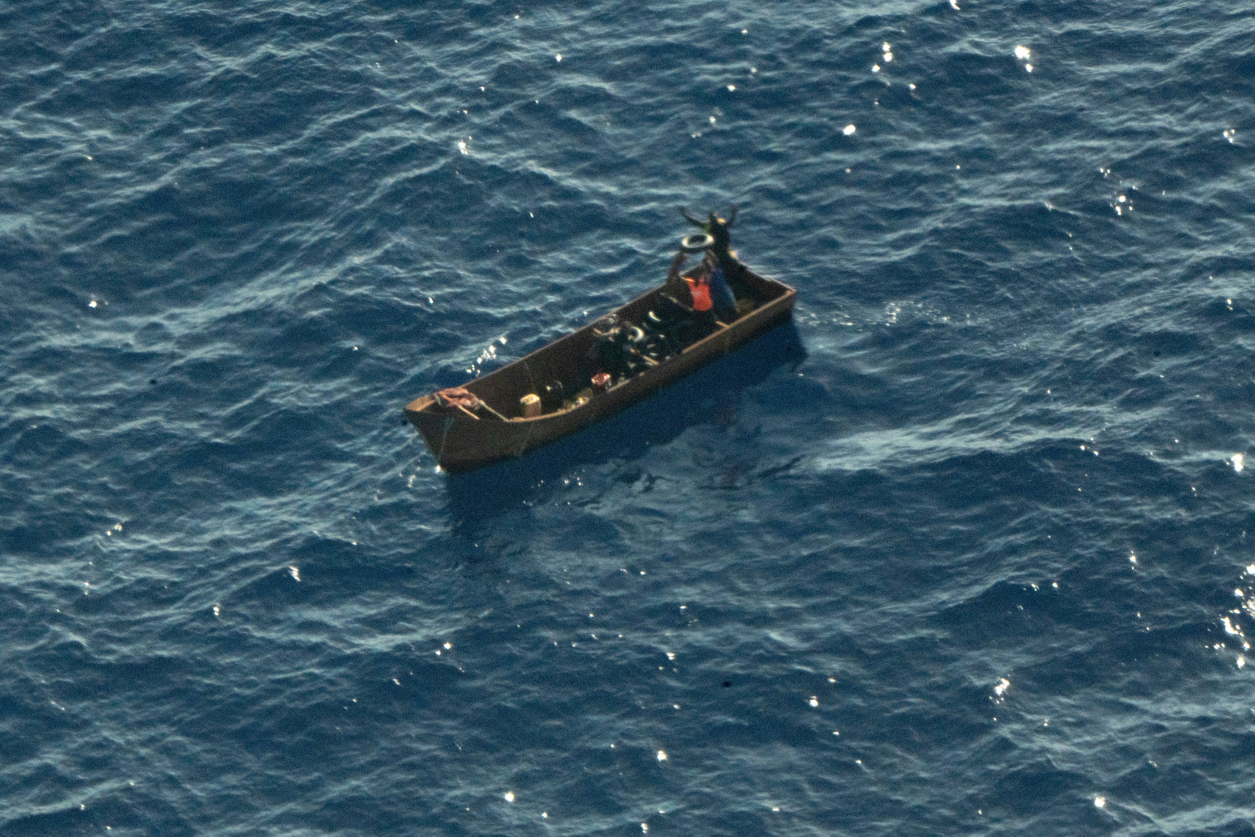 In pictures provided by Sea Watch planes four migrant survivors wave for help as they are in distress at sea