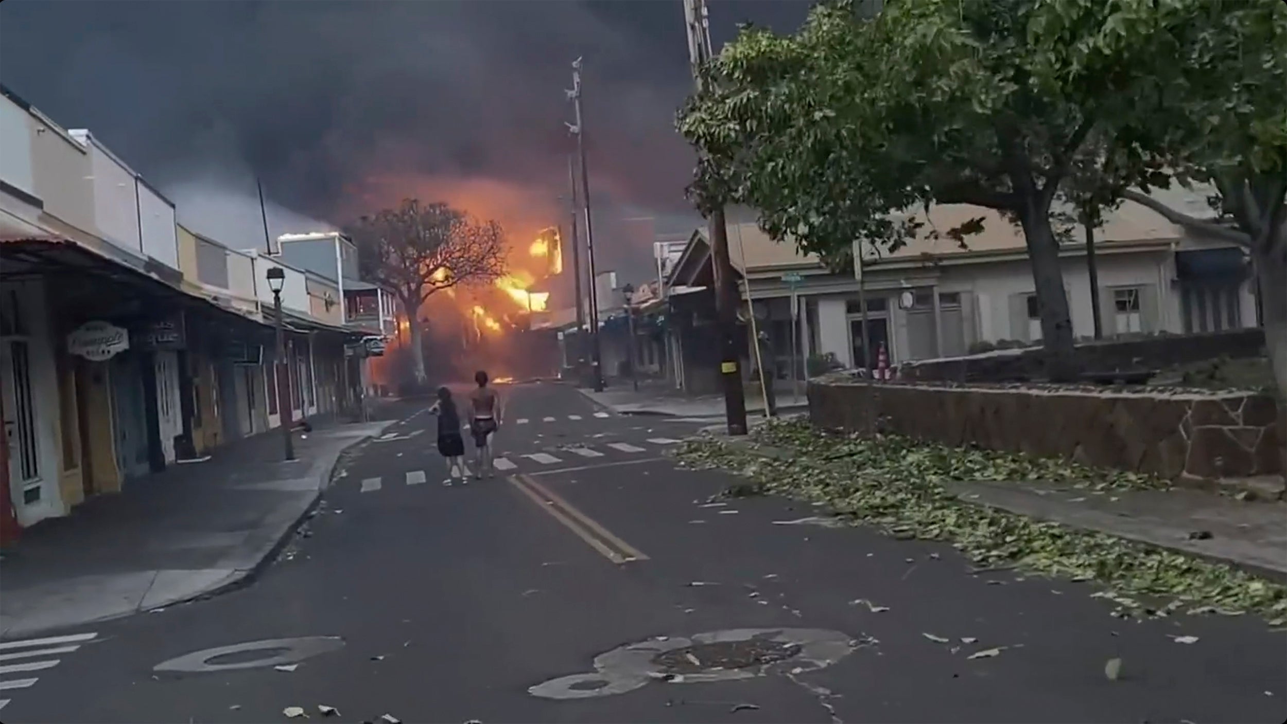 People watch as smoke and flames fill the air from raging wildfires on Front Street in downtown Lahaina, Maui on Tuesday, Aug. 9, 2023