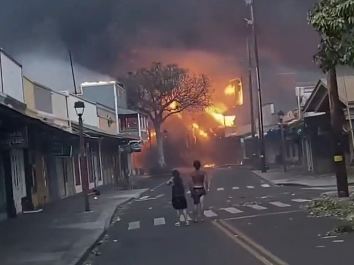 People watch as smoke and flames fill the air from raging wildfires on Front Street in downtown Lahaina, Maui on Tuesday, Aug. 9, 2023