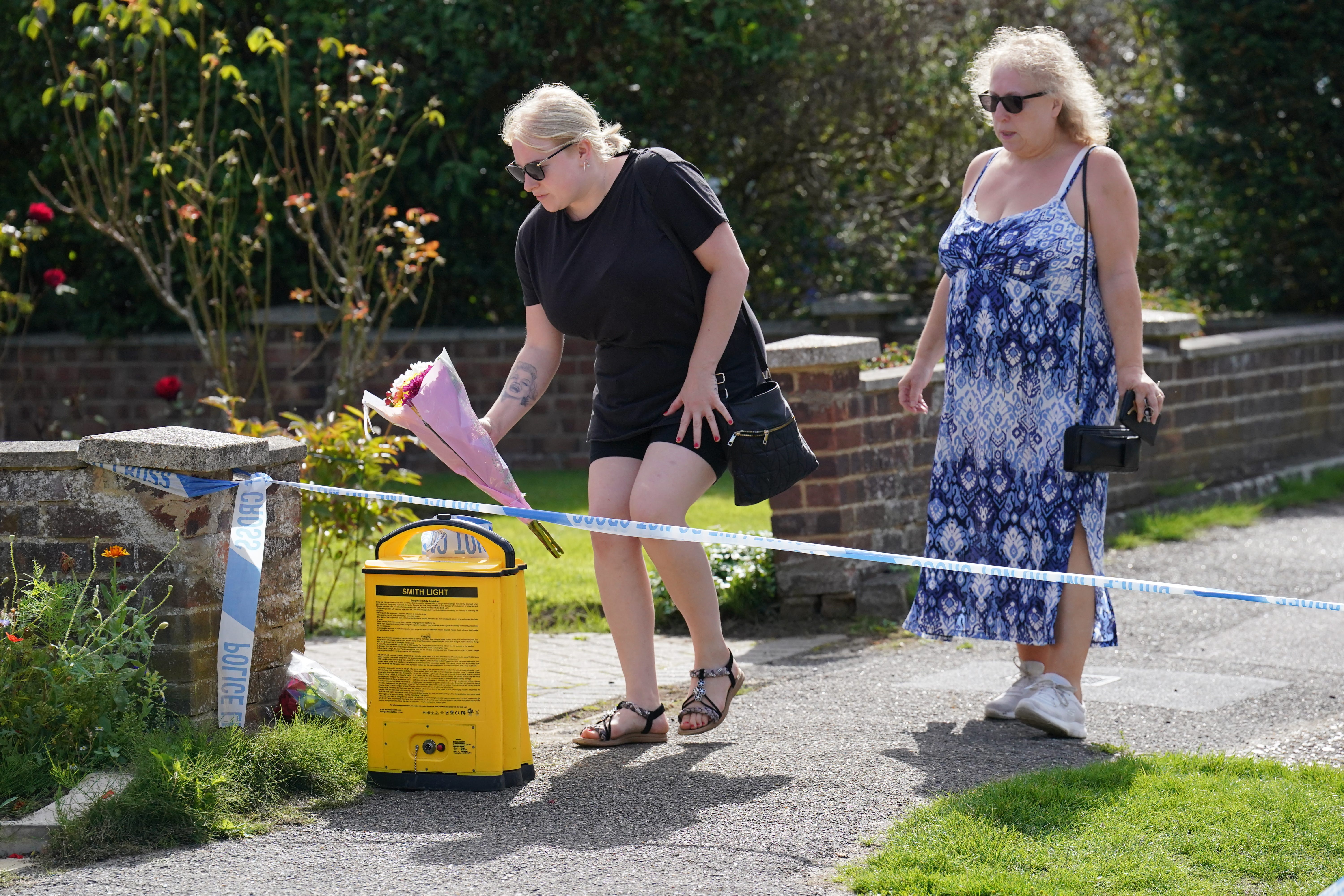 Locals left flowers outside a property on Hammond Road in Horsell, Surrey, where a 10-year-old girl was found dead (Jonathan Brady/PA)