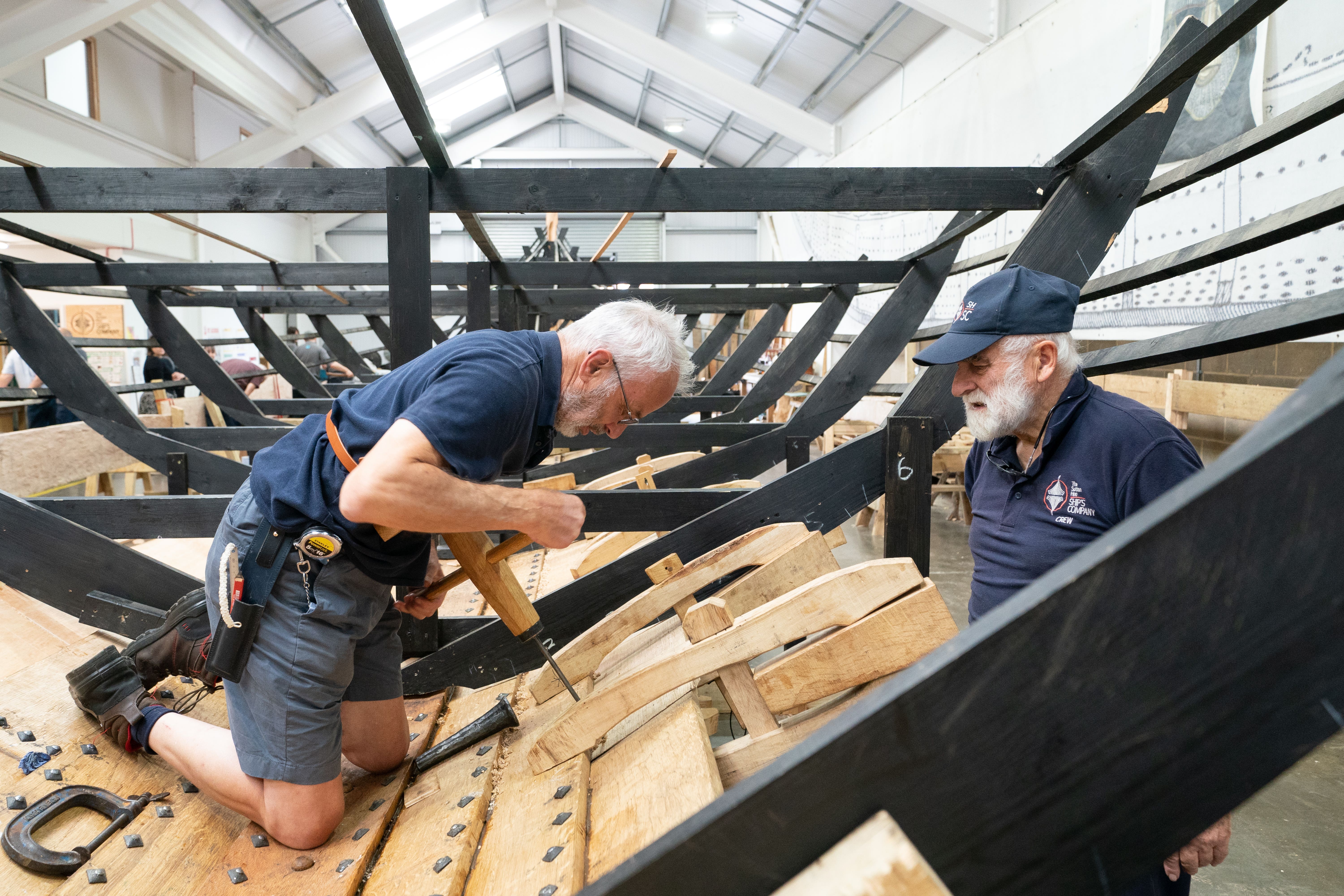 David Steptoe works on the replica of the Sutton Hoo longship, at the Longshed in Woodbridge, Suffolk (Joe Giddens/PA)