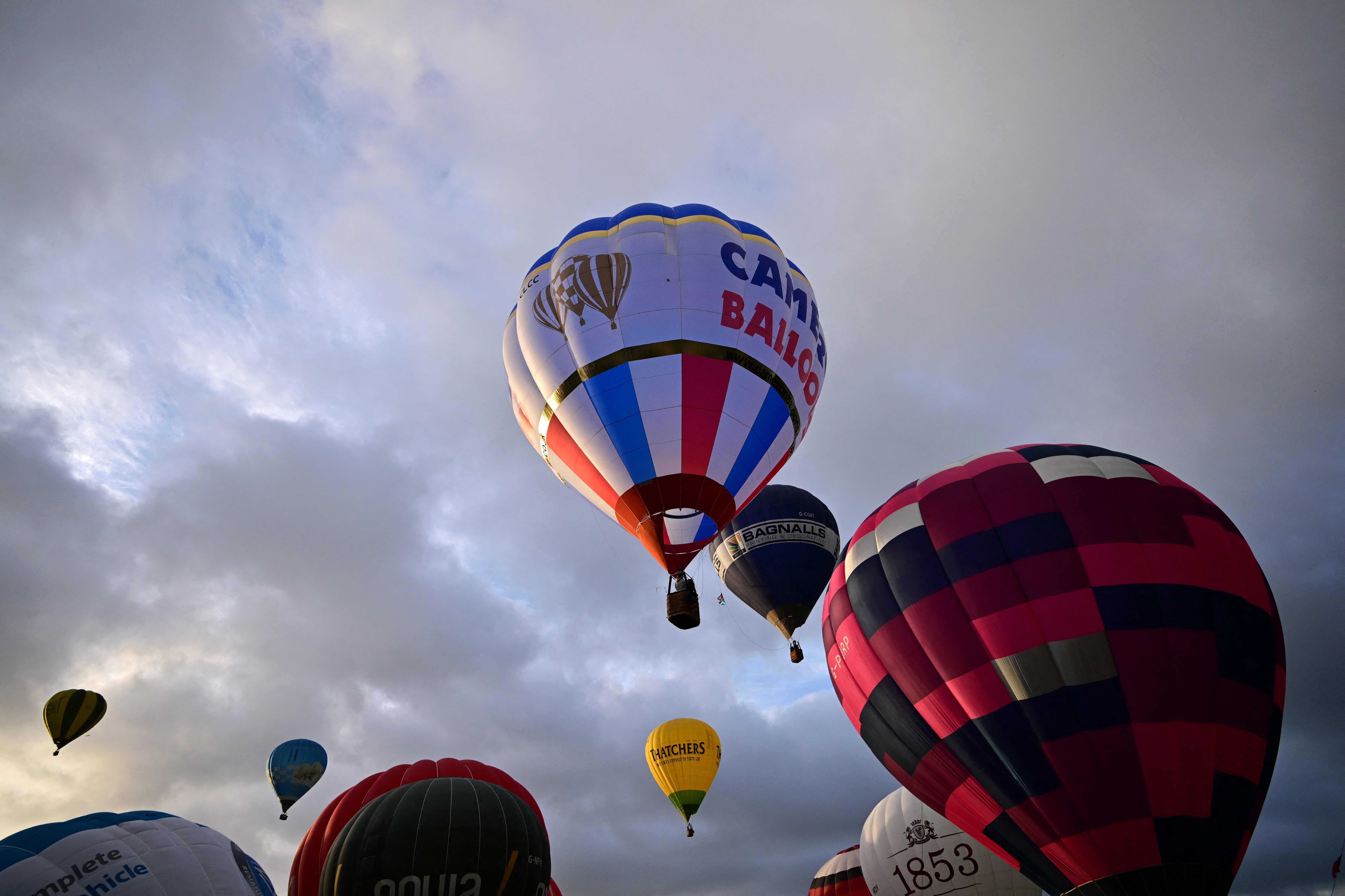 Hot air balloons take to the air in a Mass Ascent at dawn during the Bristol international balloon fiesta, in Ashton Court, in Bristol