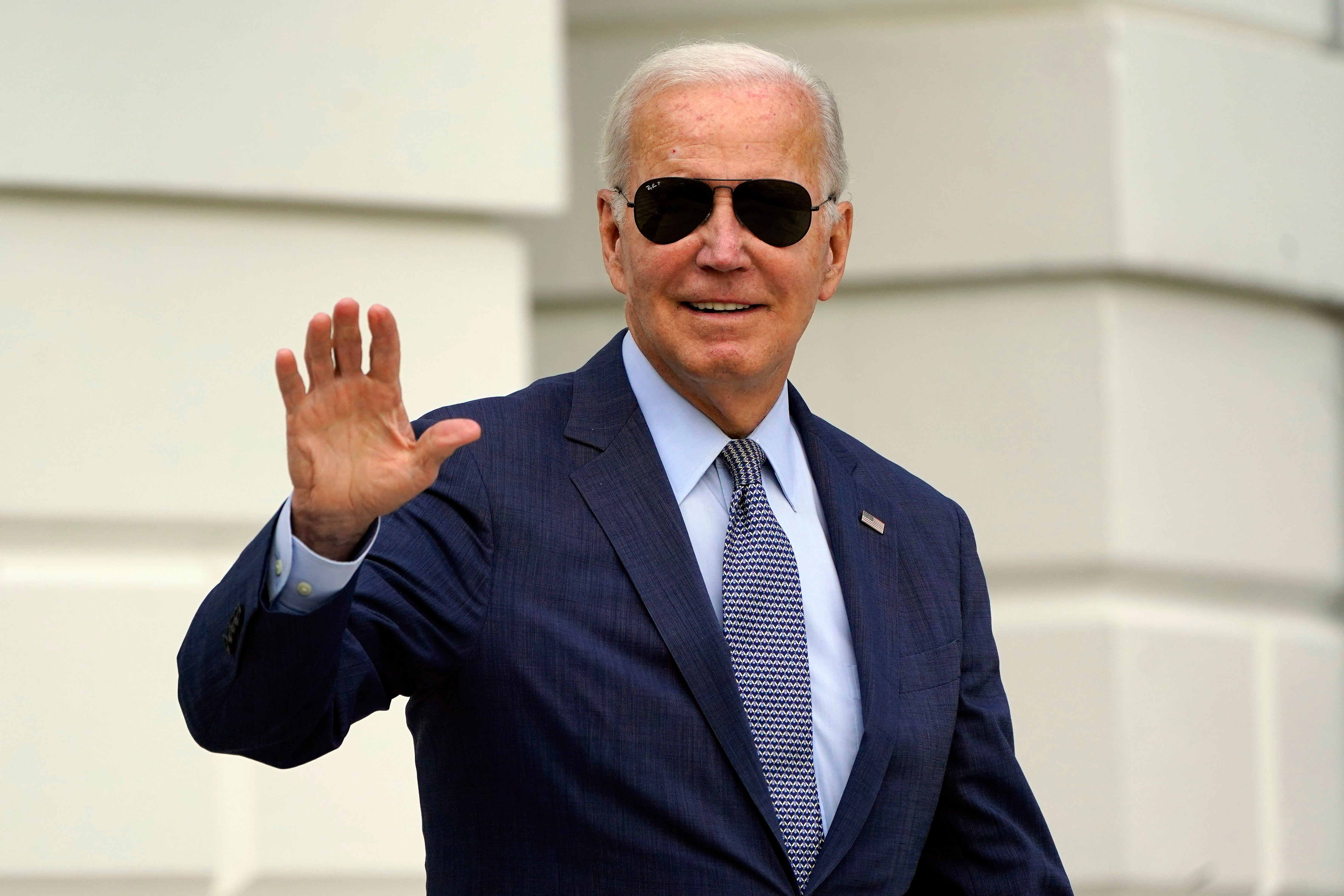 President Joe Biden waves to members of the media as he walks towards Marine One on the South Lawn of the White House on 11 August