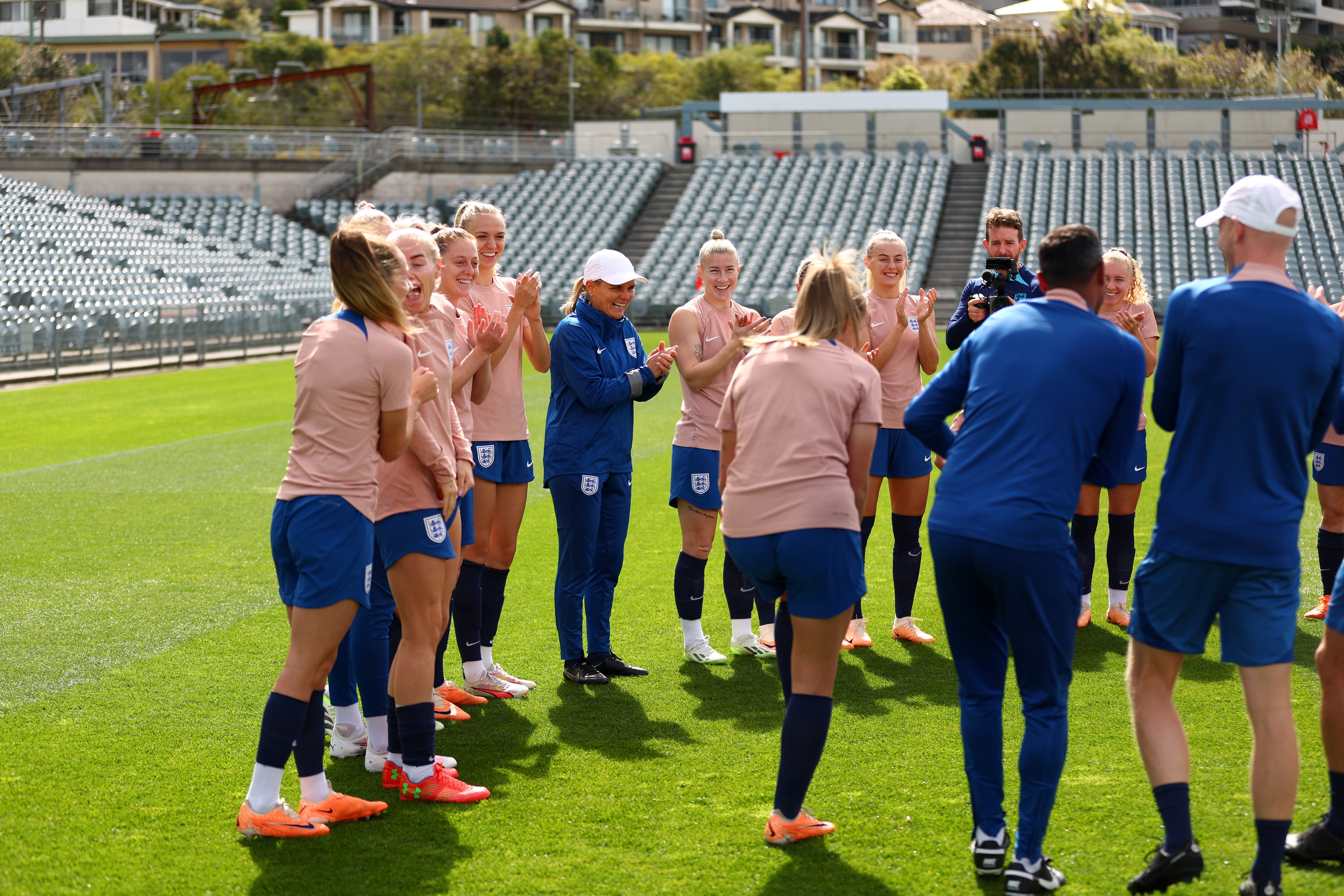 Sarina Wiegman, Manager of England, and players react during a training session