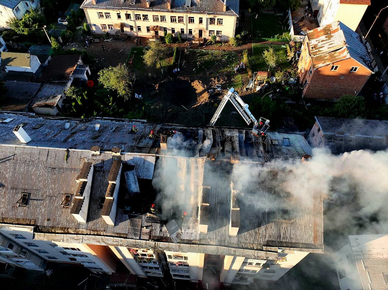 Rescuers putting out a fire in a residential building after missile strikes hit Lviv