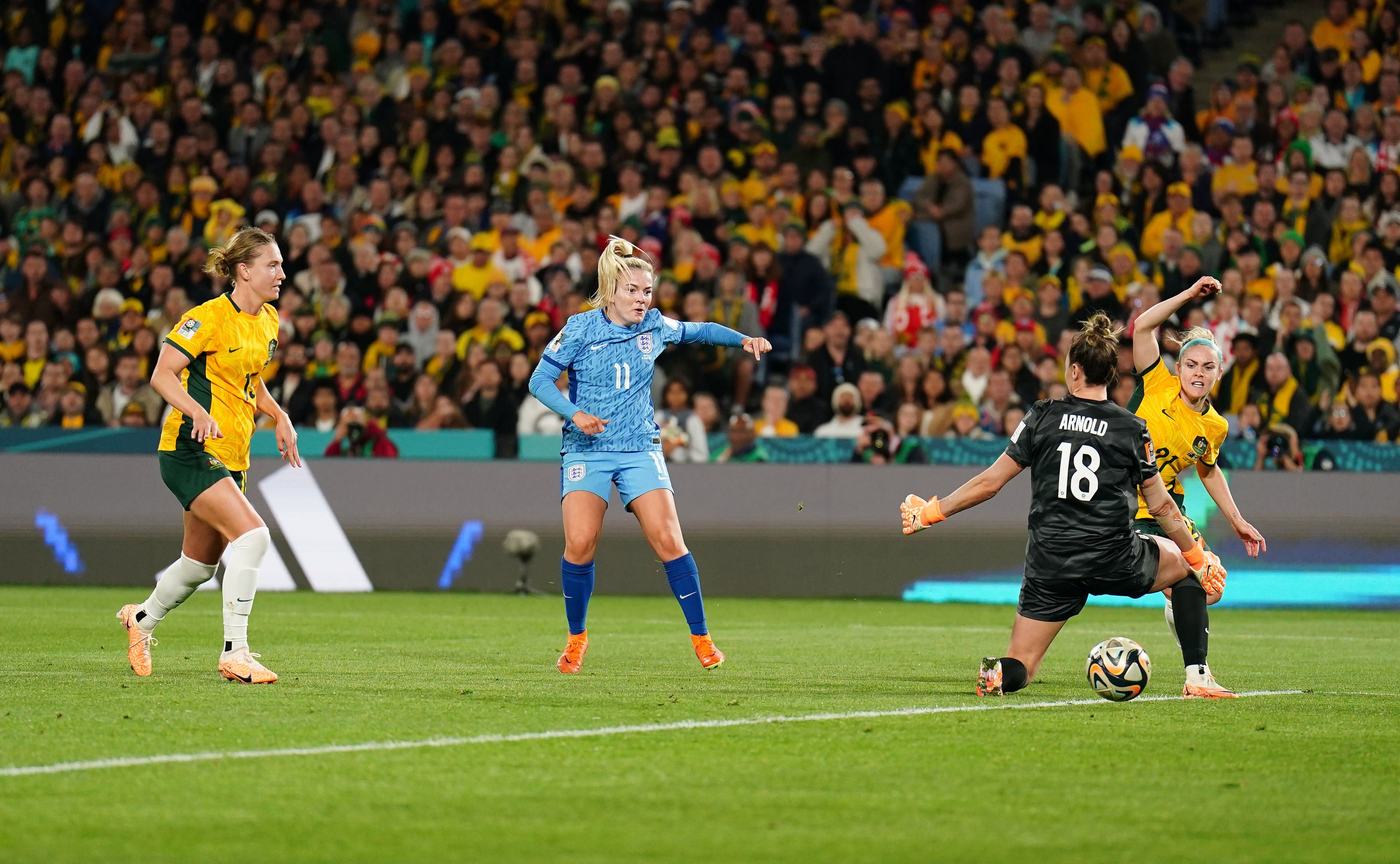 Lauren Hemp slides the ball past goalkeeper Mackenzie Arnold