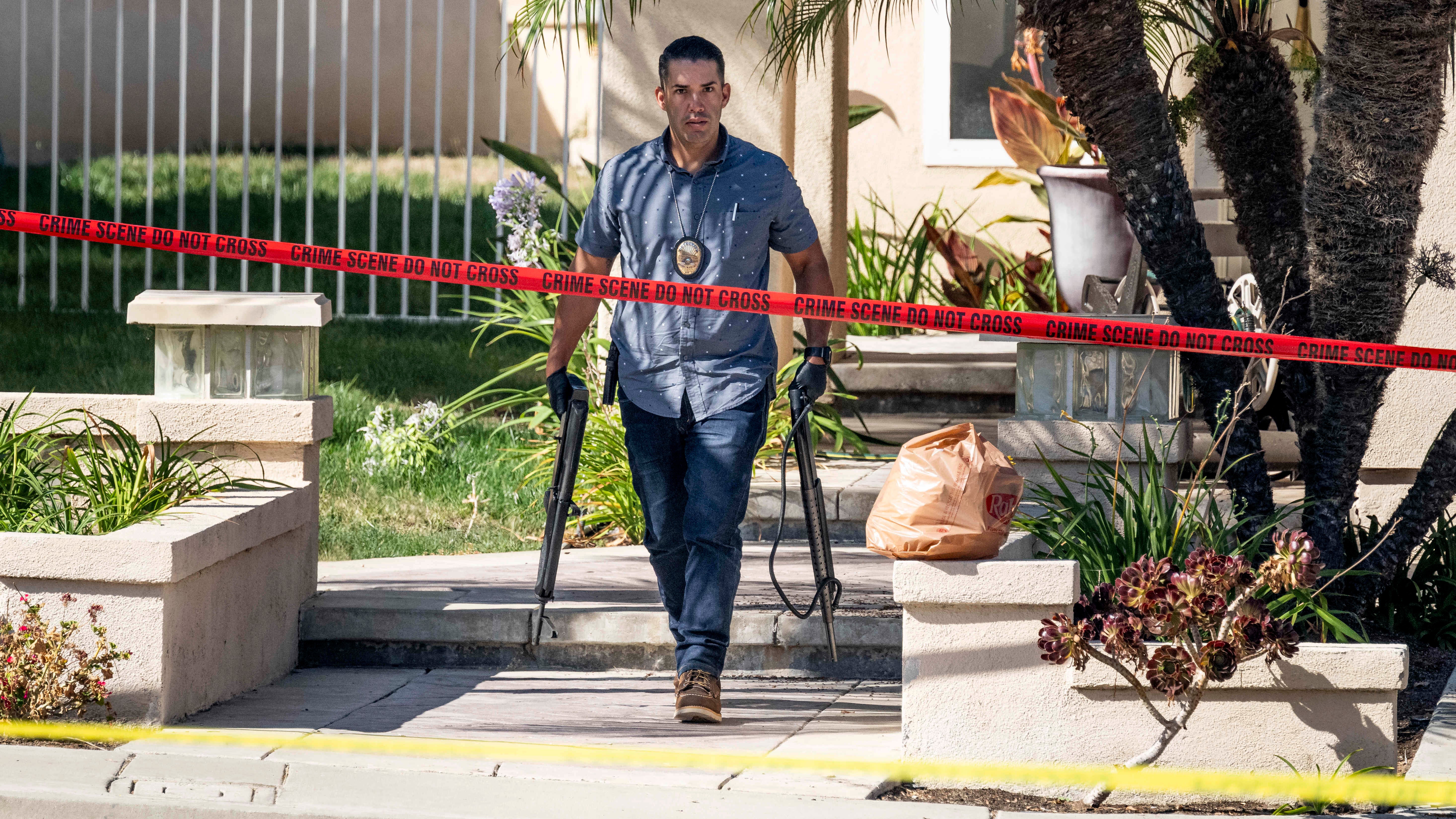 Investigators remove firearms from a house in the 8500 block of E Canyon Vista Drive in Anaheim