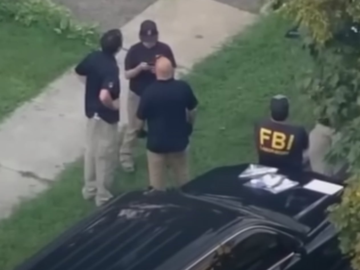 FBI agents wait outside of the home of a 17-year-old who has been accused of communicating with extremist organisations and plotting a terror attack