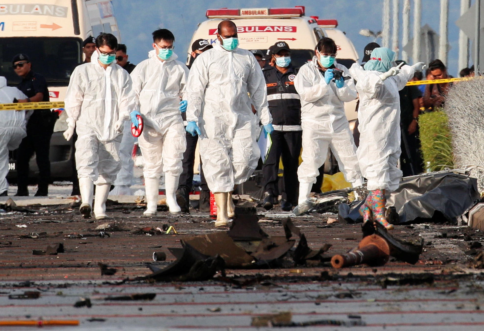 Authorities inspect the scene of a plane crash in Shah Alam, Malaysia