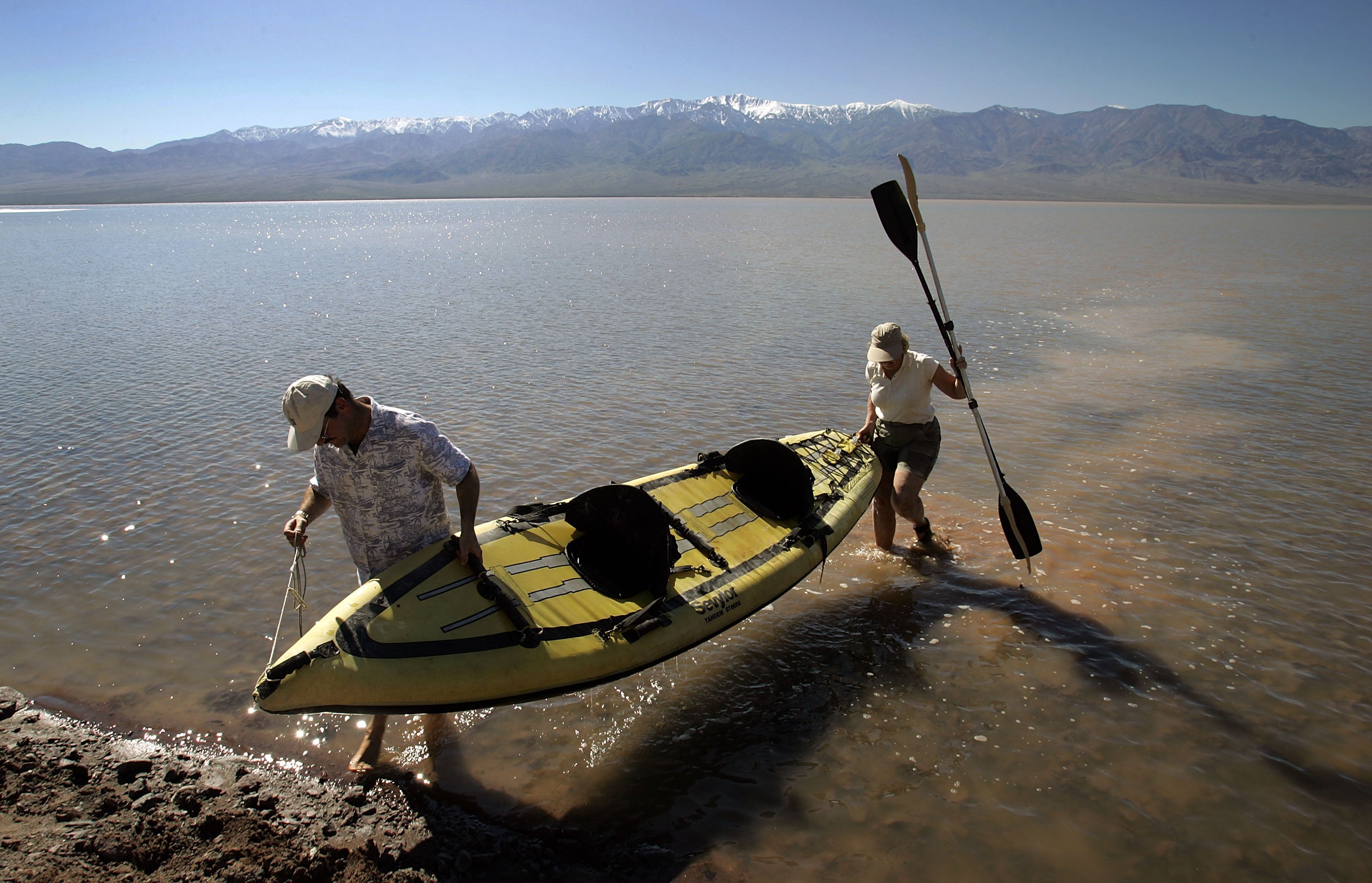 Jay Shapiro, left, of Thousand Oaks, California, and Cheryl Cox, of Ventura, California come ashore after kayaking in a giant lake in the bottom of Death Valley caused by heavy flooding in 2005