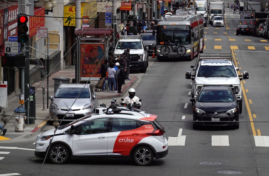 A Chevrolet Cruise autonomous vehicle with a driver moves through an intersection in San Francisco