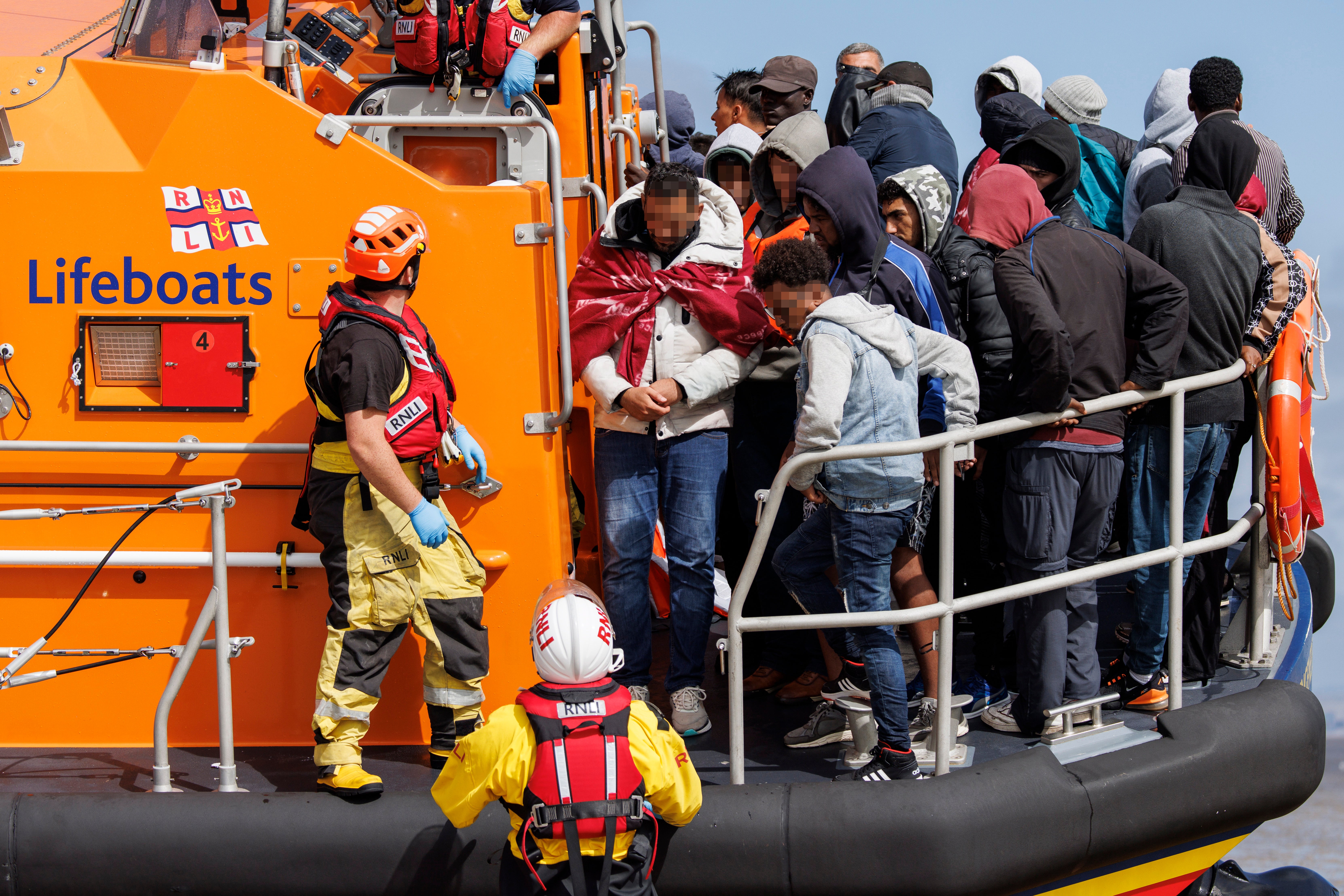 Migrants rescued from a boat crossing the English Channel land on Dungeness Beach in Kent, 21 August 2023