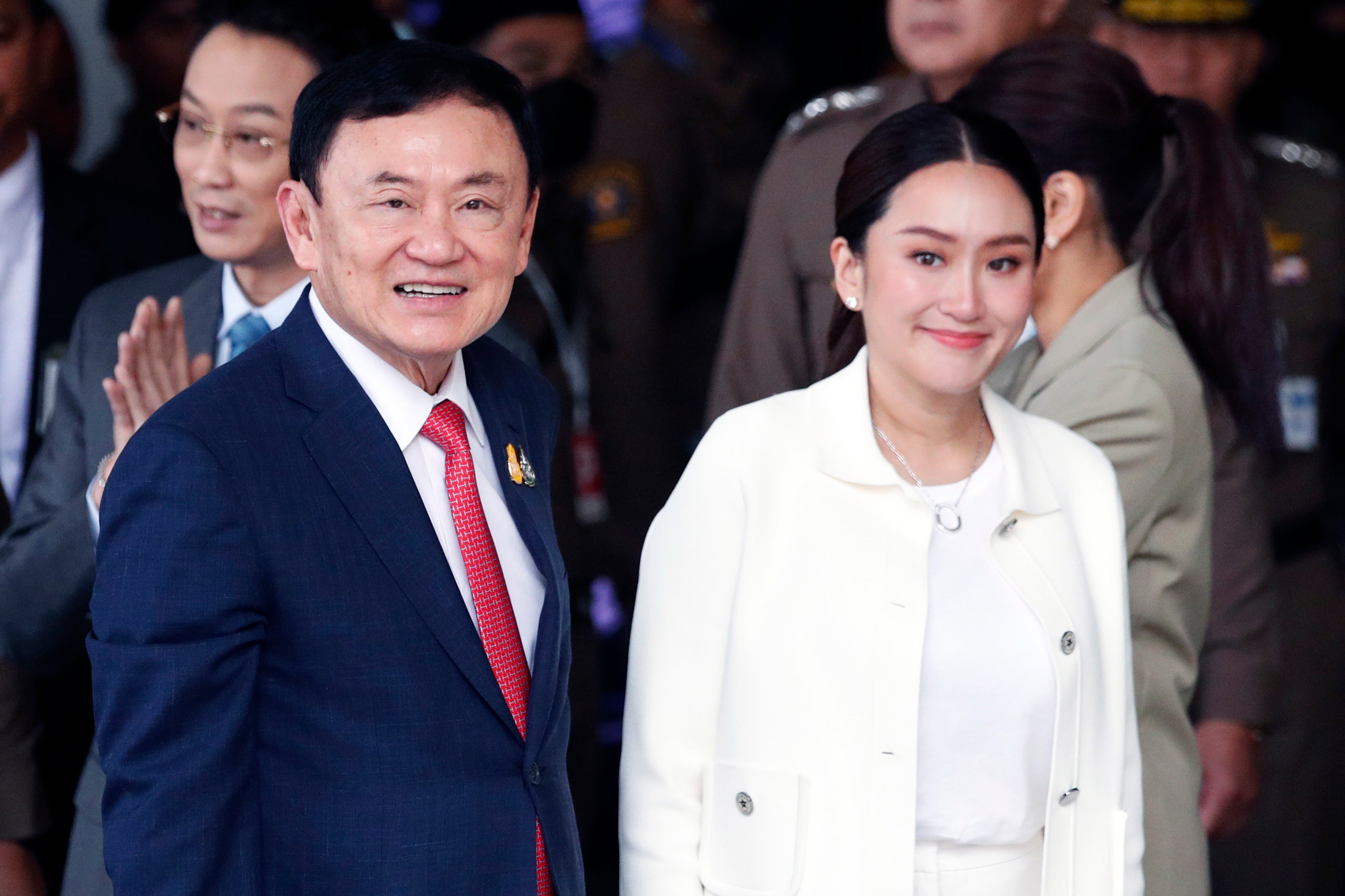 Former Thai prime minister Thaksin Shinawatra smiles next to his daughter and Pheu Thai Party prime ministerial candidate Paetongtarn Shinawatra