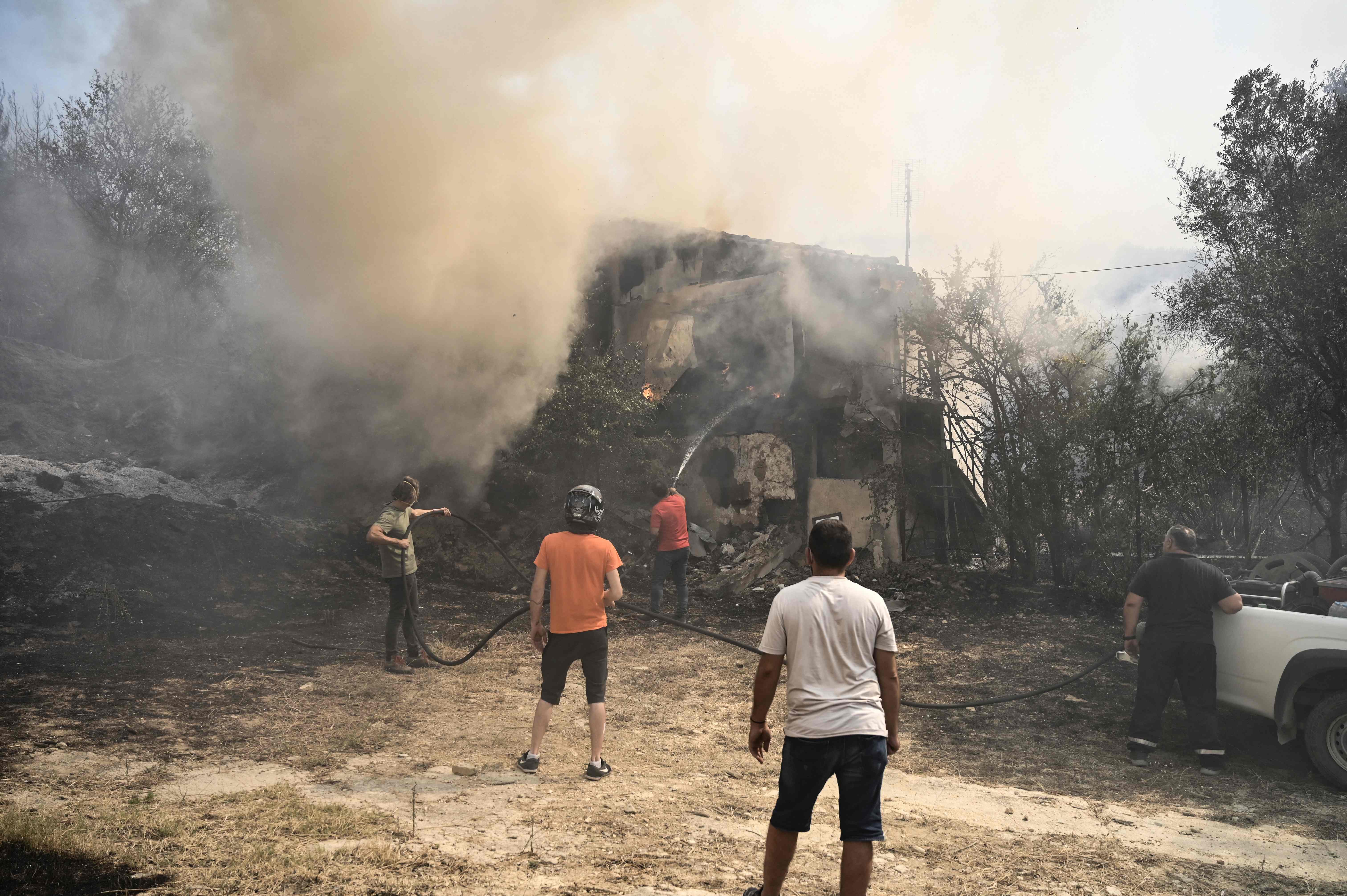 Local residents seen extinguishing a fire in Avanta as smoke covers the air