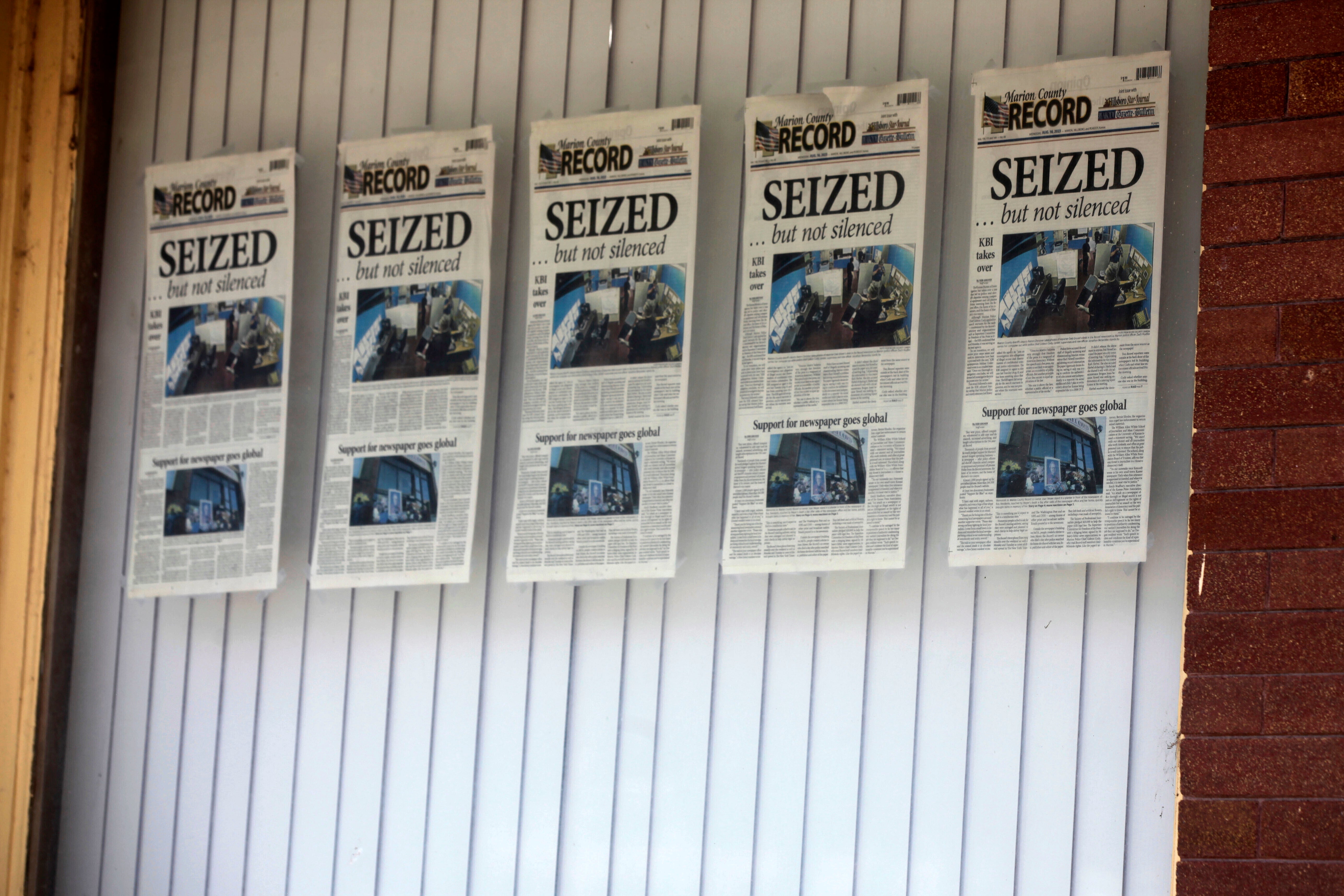 Front pages for the Marion County Record’s latest weekly edition are displayed on a window at its offices