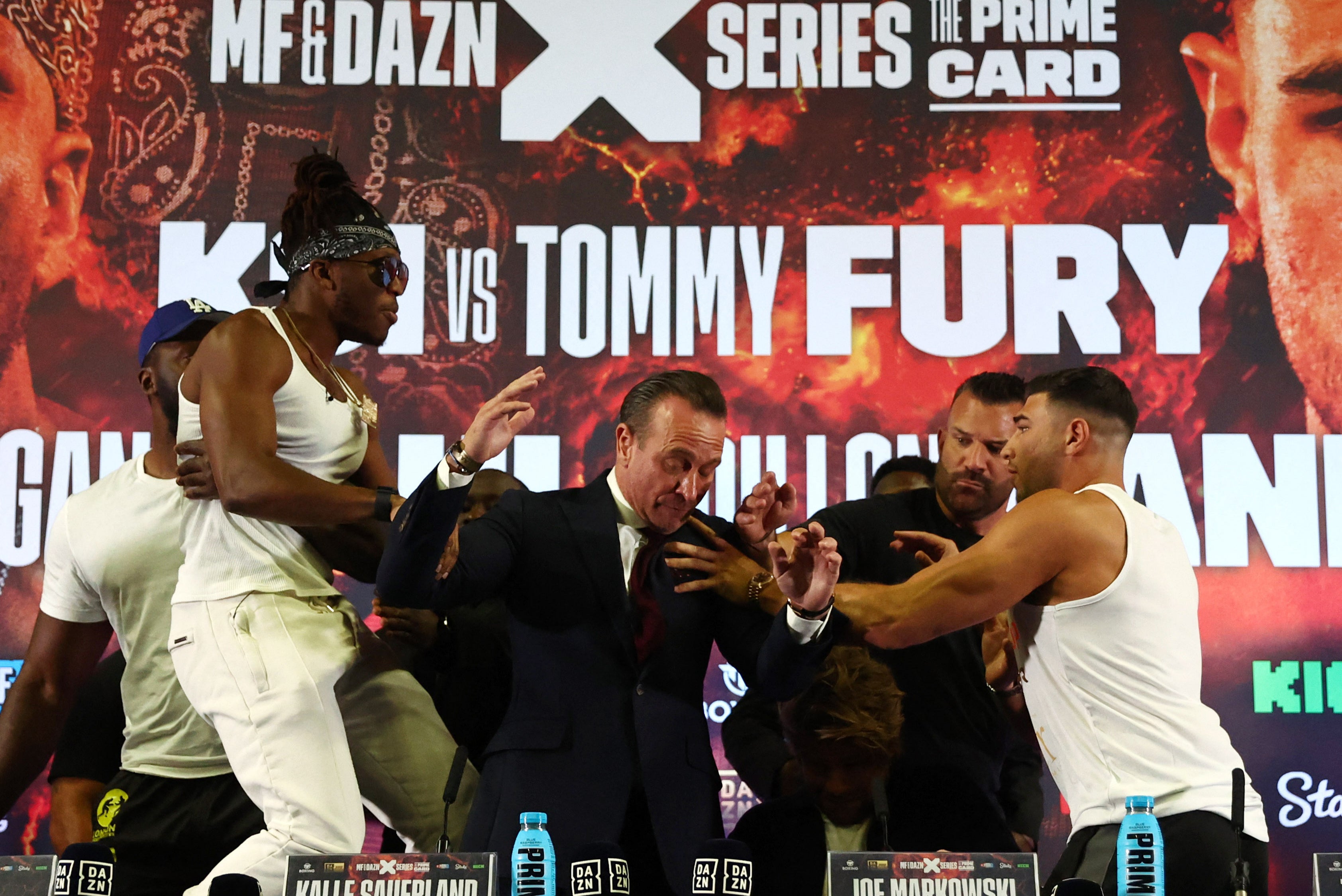 KSI, left, is held back as Tommy Fury tries to lay hands on him