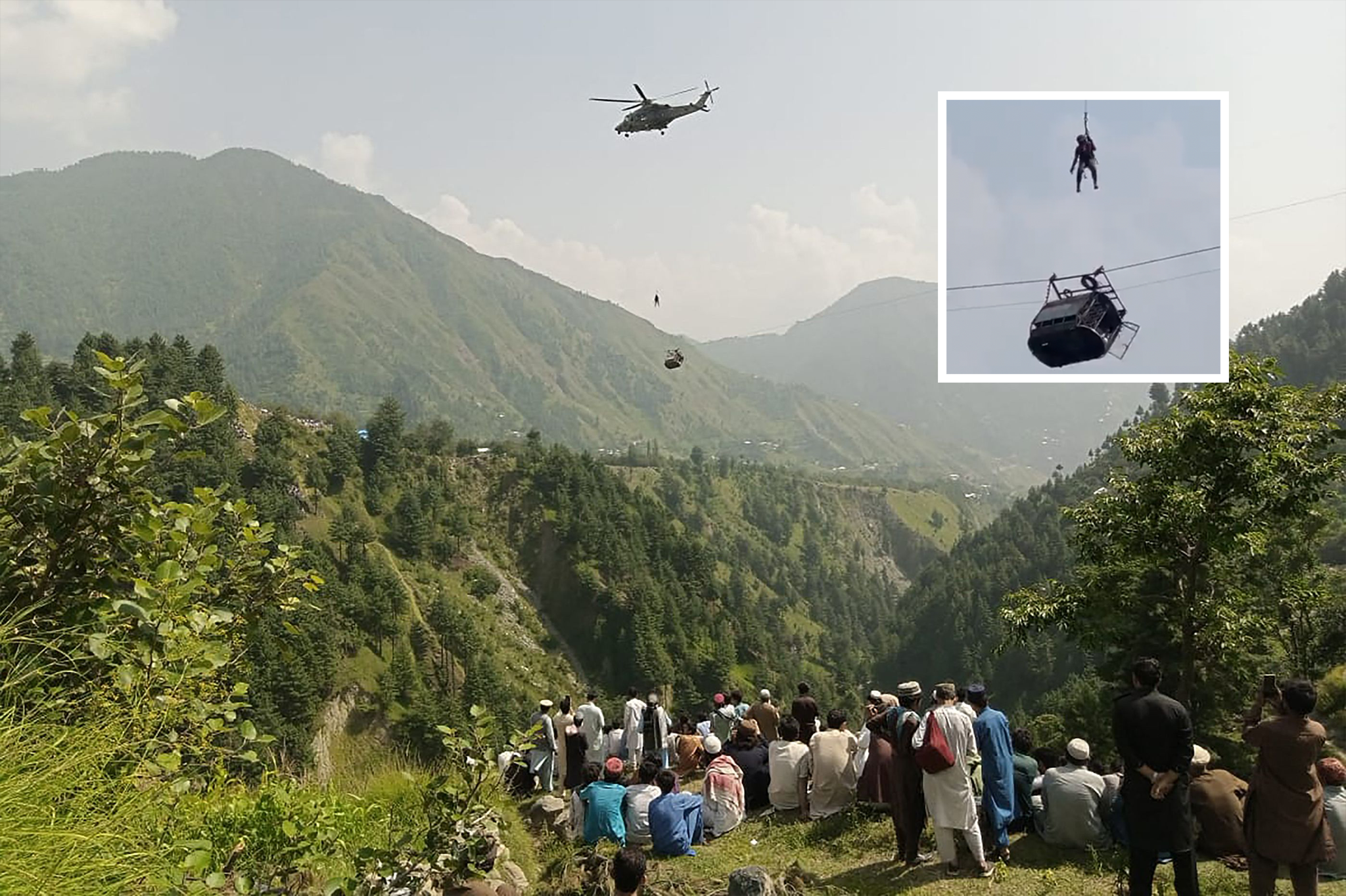 People watch as a soldier dangled from a helicopter during the rescue mission