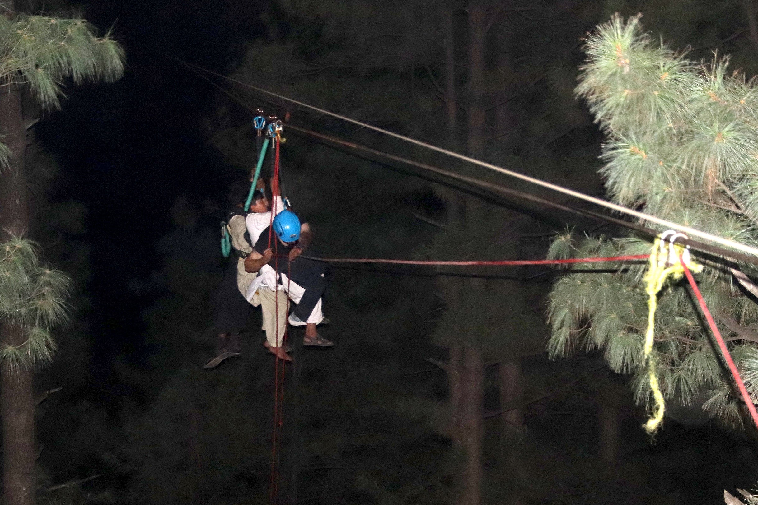 A child is brough to safety along a zip line