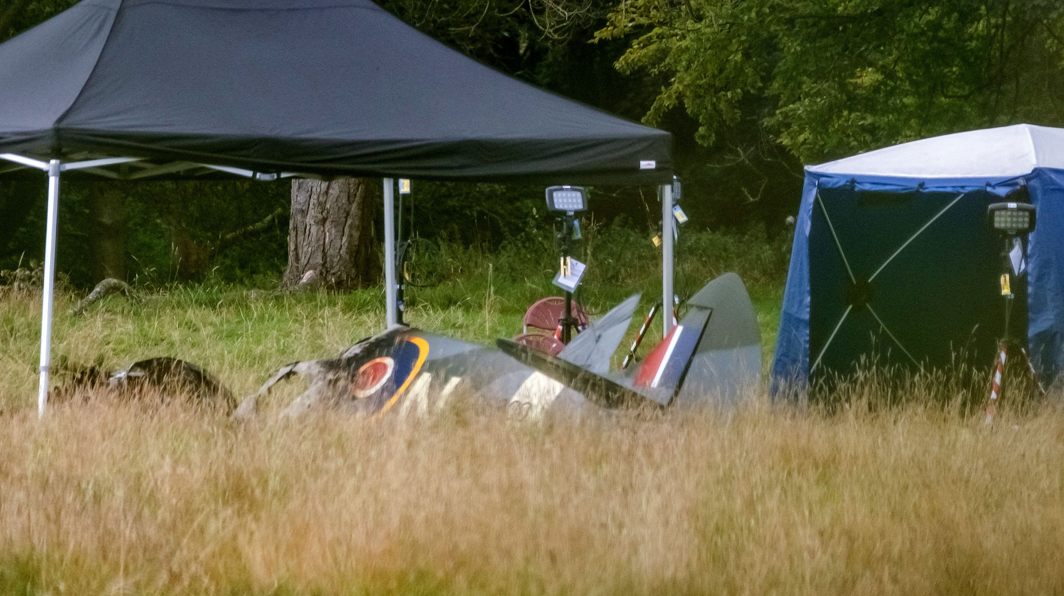 Police and emergency responders at the scene of an aircraft crash in a field near Enstoe