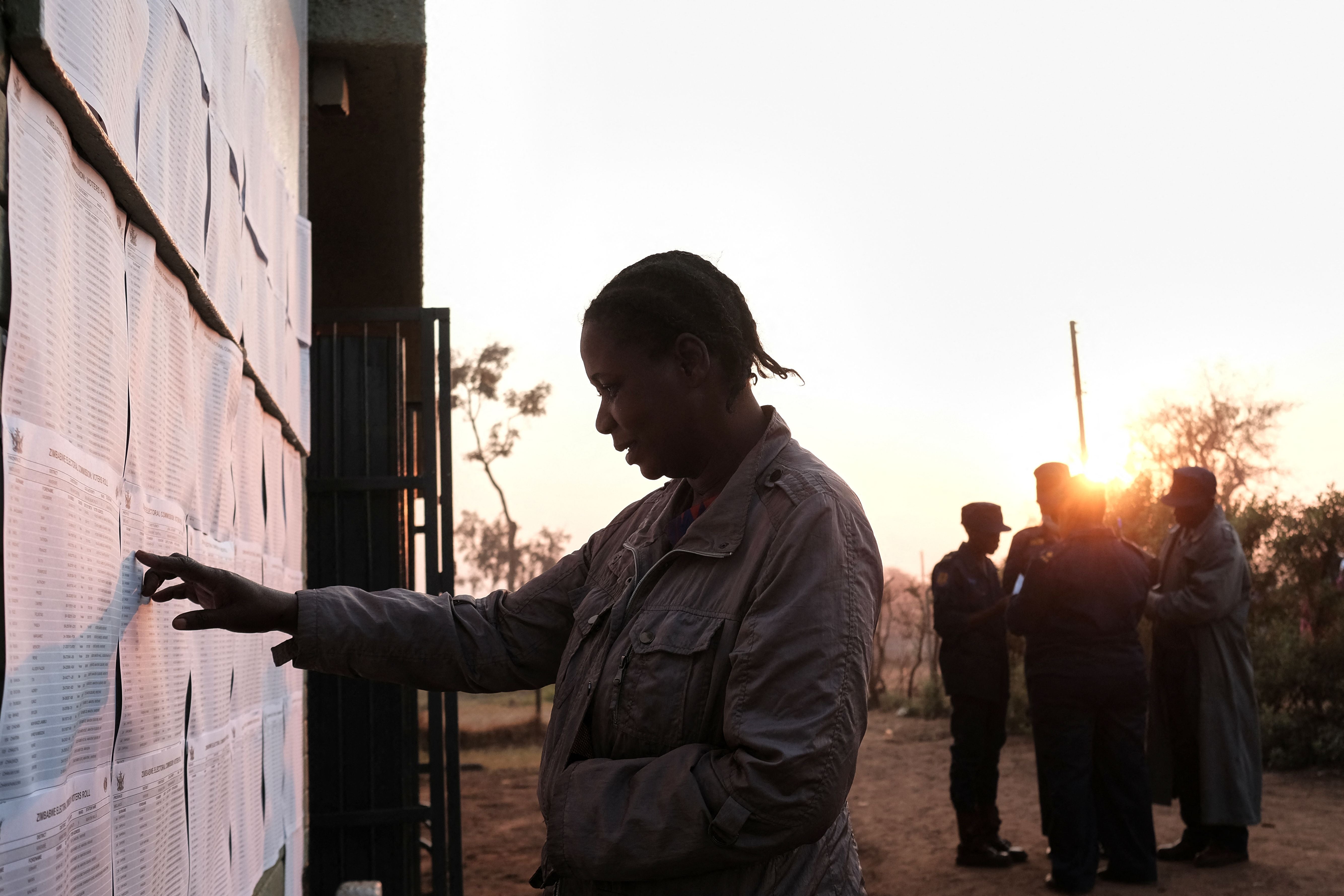 A woman looks for her name on a voters list in Zimbabwe on Wednesday