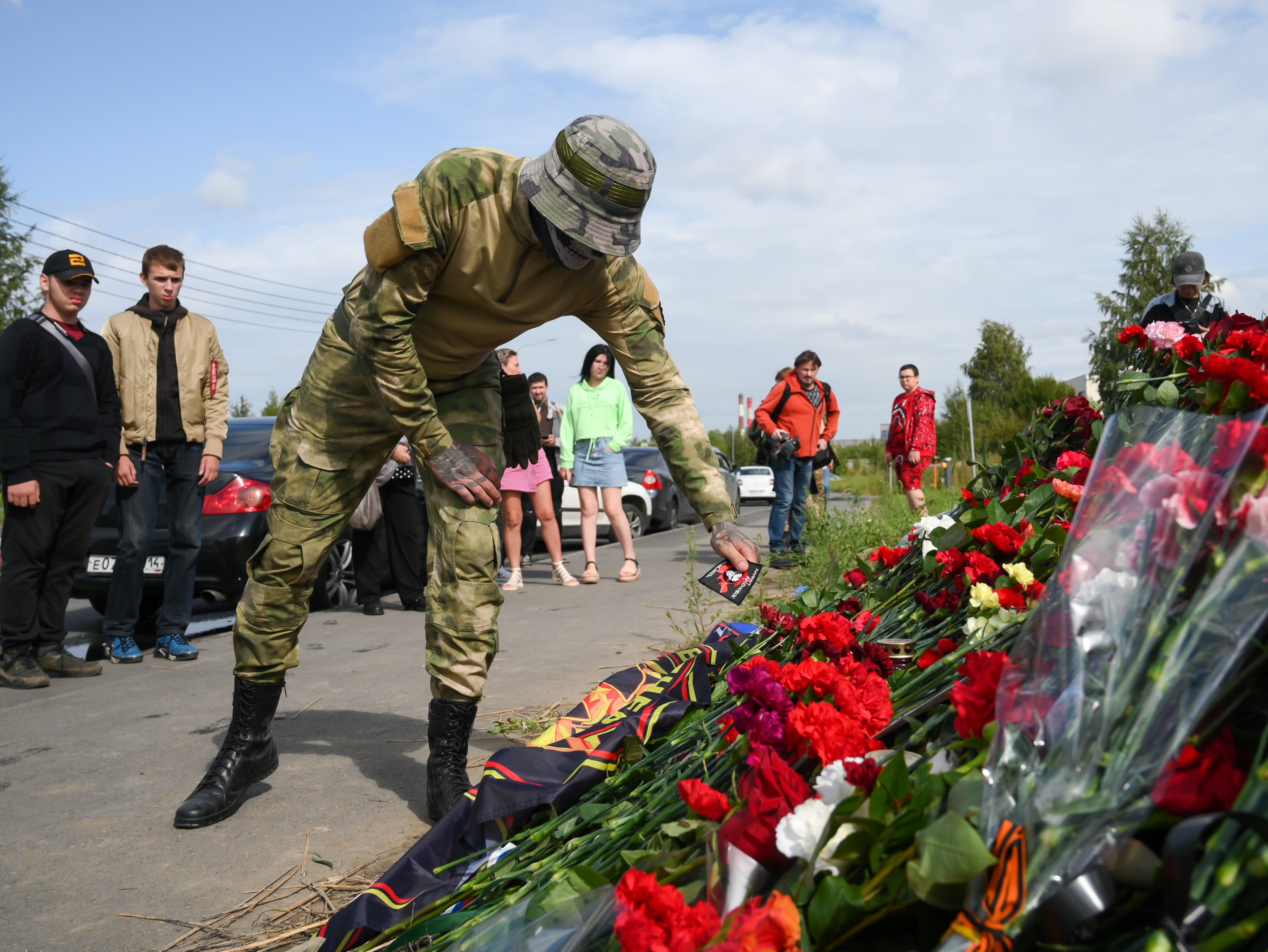 A man brings flowers at an informal memorial next to the former 'PMC Wagner Centre' in St Petersburg, Russia